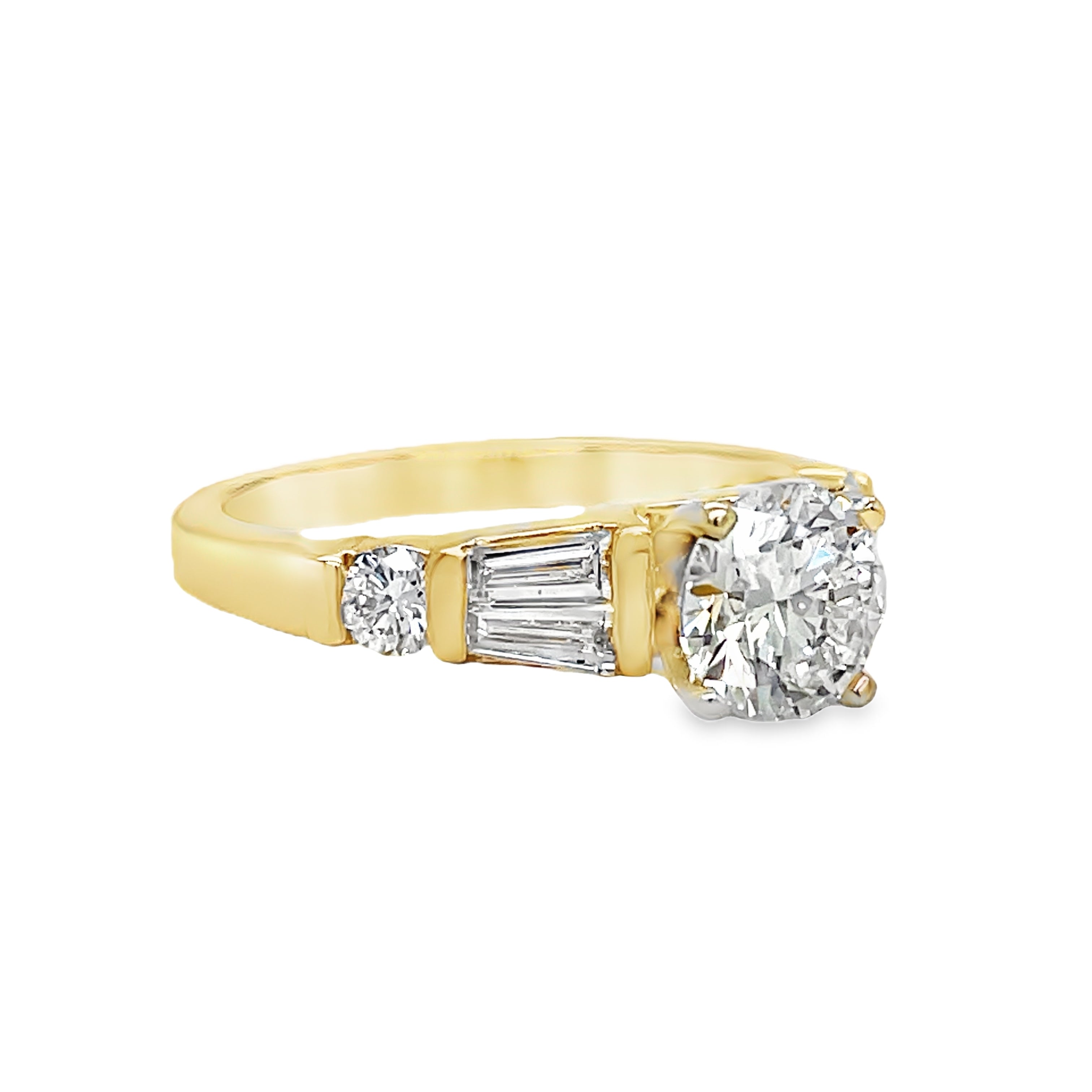 ndulge in luxury with this Round Brilliant Diamond &amp; Baguette Engagement Ring. With a striking 1.02 ct round brilliant diamond, framed by tapered baguette diamonds and two small round diamonds totaling 0.40 cts, this exquisite ring exudes elegance and sophistication. Crafted in 14k yellow gold, it's the perfect symbol of your love.