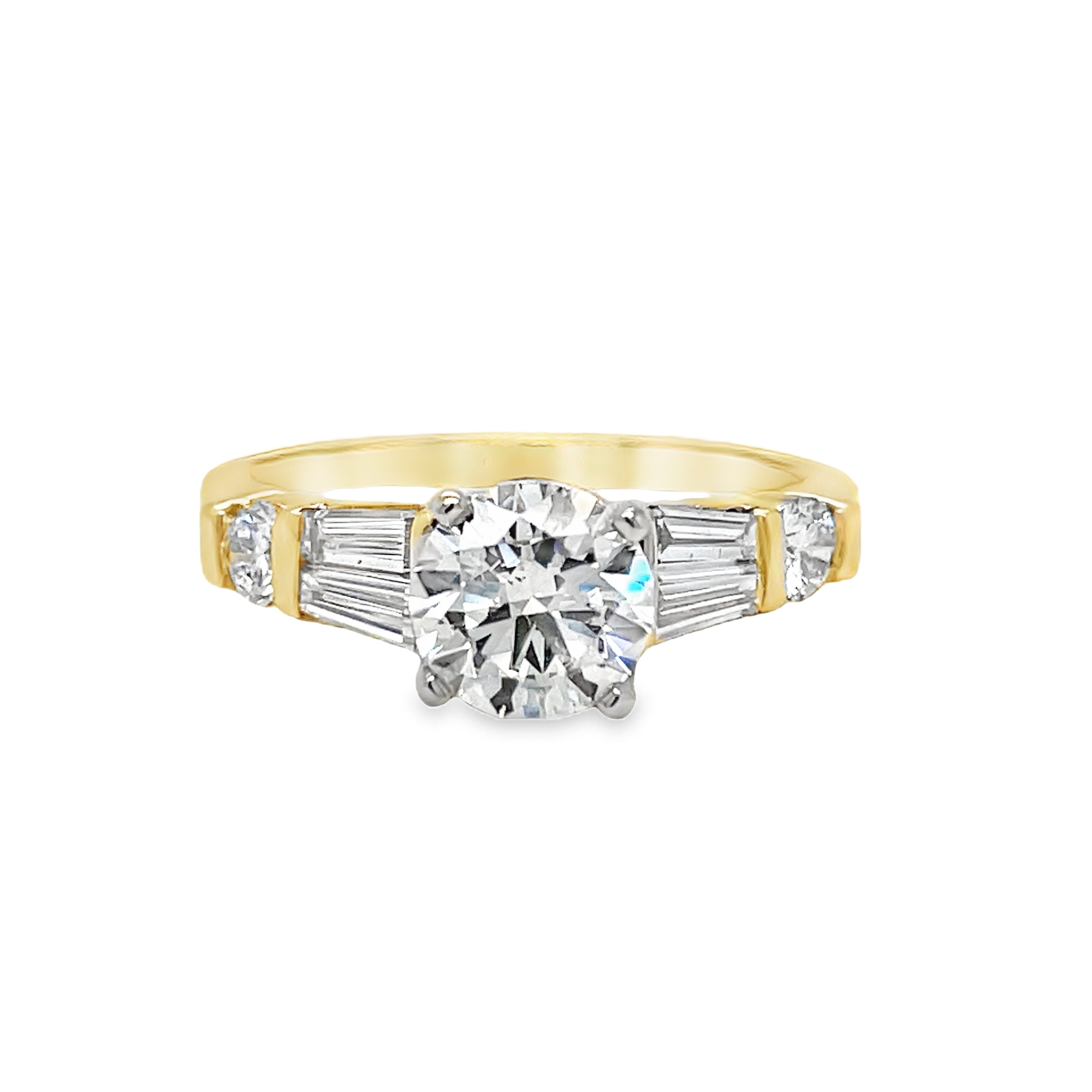 ndulge in luxury with this Round Brilliant Diamond &amp; Baguette Engagement Ring. With a striking 1.02 ct round brilliant diamond, framed by tapered baguette diamonds and two small round diamonds totaling 0.40 cts, this exquisite ring exudes elegance and sophistication. Crafted in 14k yellow gold, it's the perfect symbol of your love.