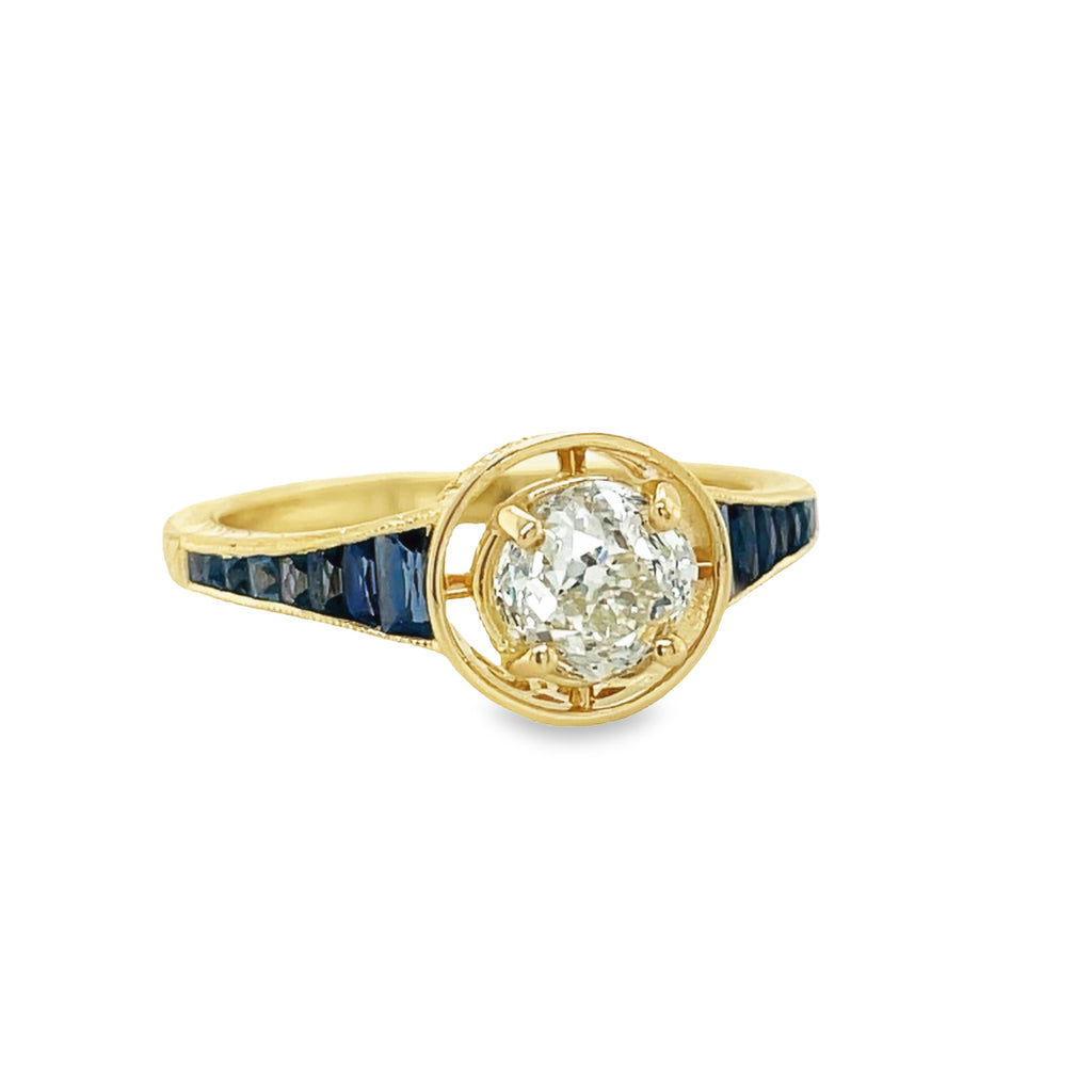 This unique Art Deco Solitaire Diamond & Sapphire Ring is perfect for those seeking an enchanting statement piece. Showcasing a sparkling 0.90 carat diamond, surrounded by a timeless pattern of 0.50 carats of deep blue antique-cut sapphires, all set in 14k yellow gold. A truly eye-catching piece.