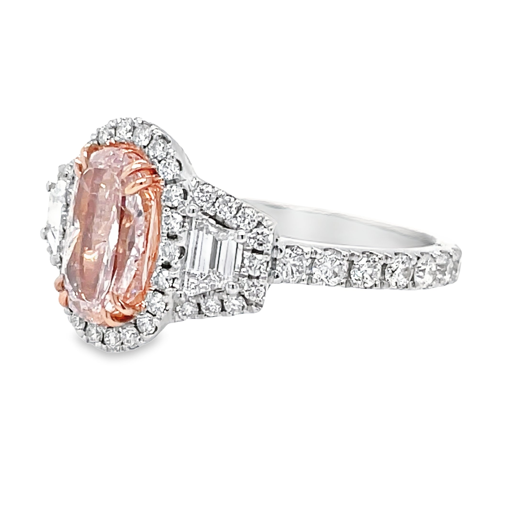 "Indulge in the rare beauty of our GIA certified 1.40 carat oval shaped pink diamond engagement ring. With two kite shaped diamonds and a round diamond bezel totaling 0.90 carats, this 18k white gold ring radiates sophistication and luxury. Make every moment sparkle with this stunning, one-of-a-kind piece."