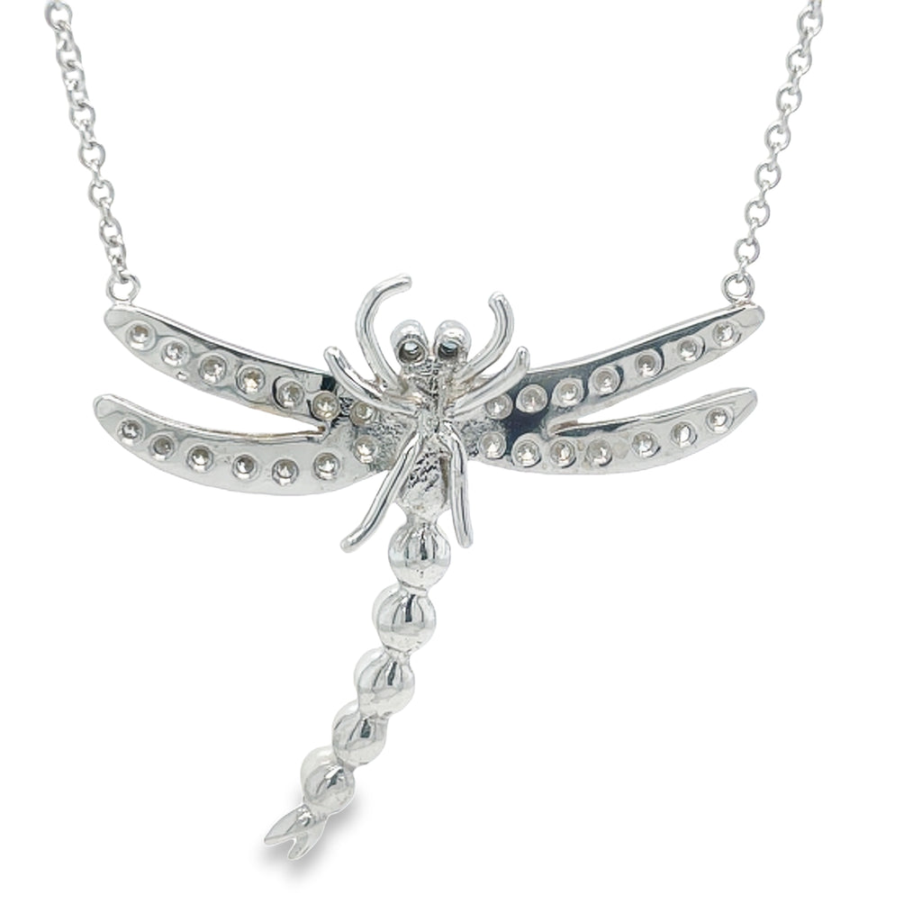 Unleash your inner elegance with our custom-made Diamond & Pearl Dragonfly Pendant Necklace! This stunning pendant features sparkling round diamonds totaling 0.98 carats, delicately arranged on a dragonfly design. Adorned with 7 cultured pearls and set on an 18" white gold chain, this pendant hangs at 1.5 inches long and wide. Elevate any outfit with this exquisite piece!