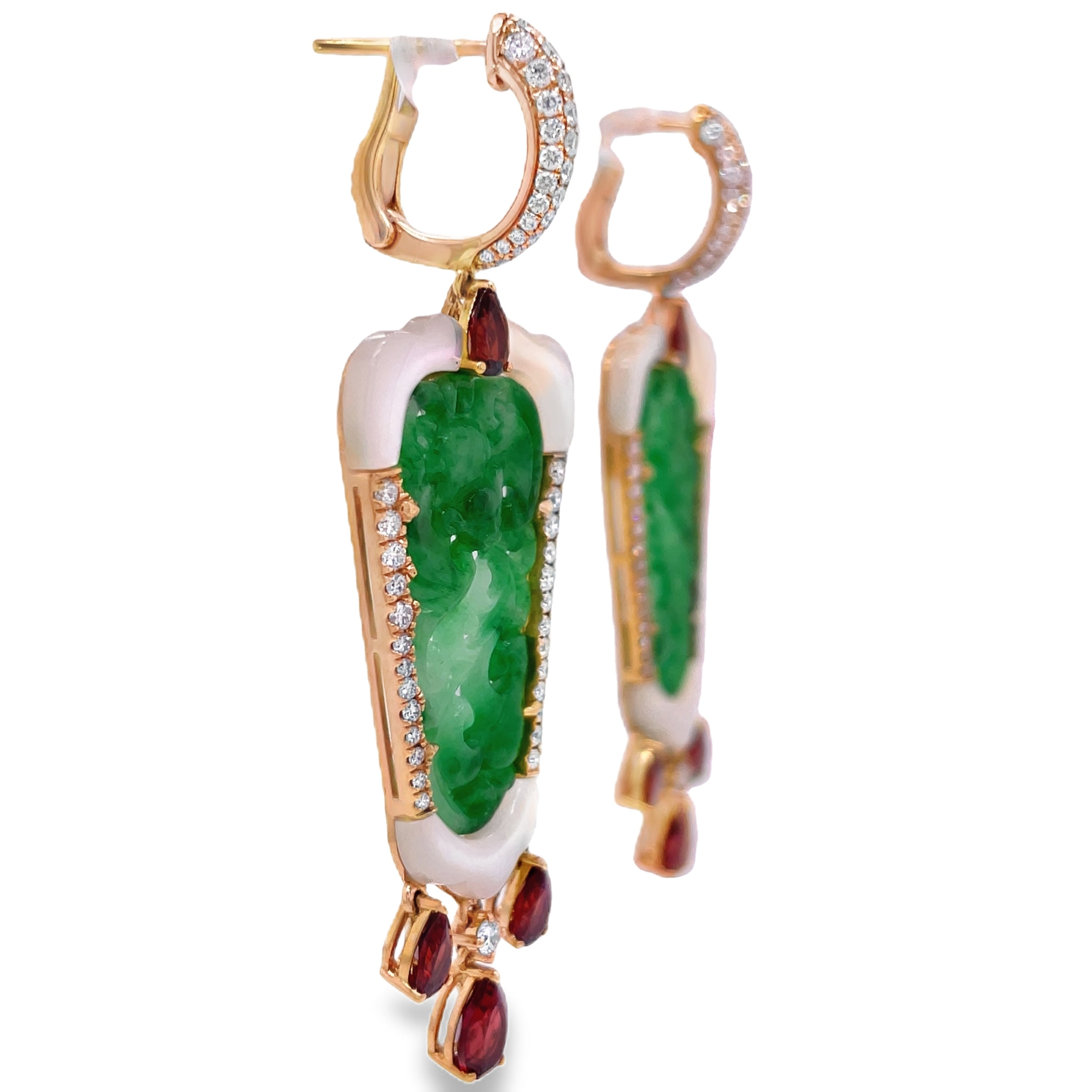 Elevate your style with these stunning green jade earrings hand carved with mother pearl and dazzling round diamonds. The dangling pear shape garnets add a touch of elegance to this 18k yellow gold design. With a secure huggie system, these earrings are 2.5" long. Own a piece of art that will make you stand out.