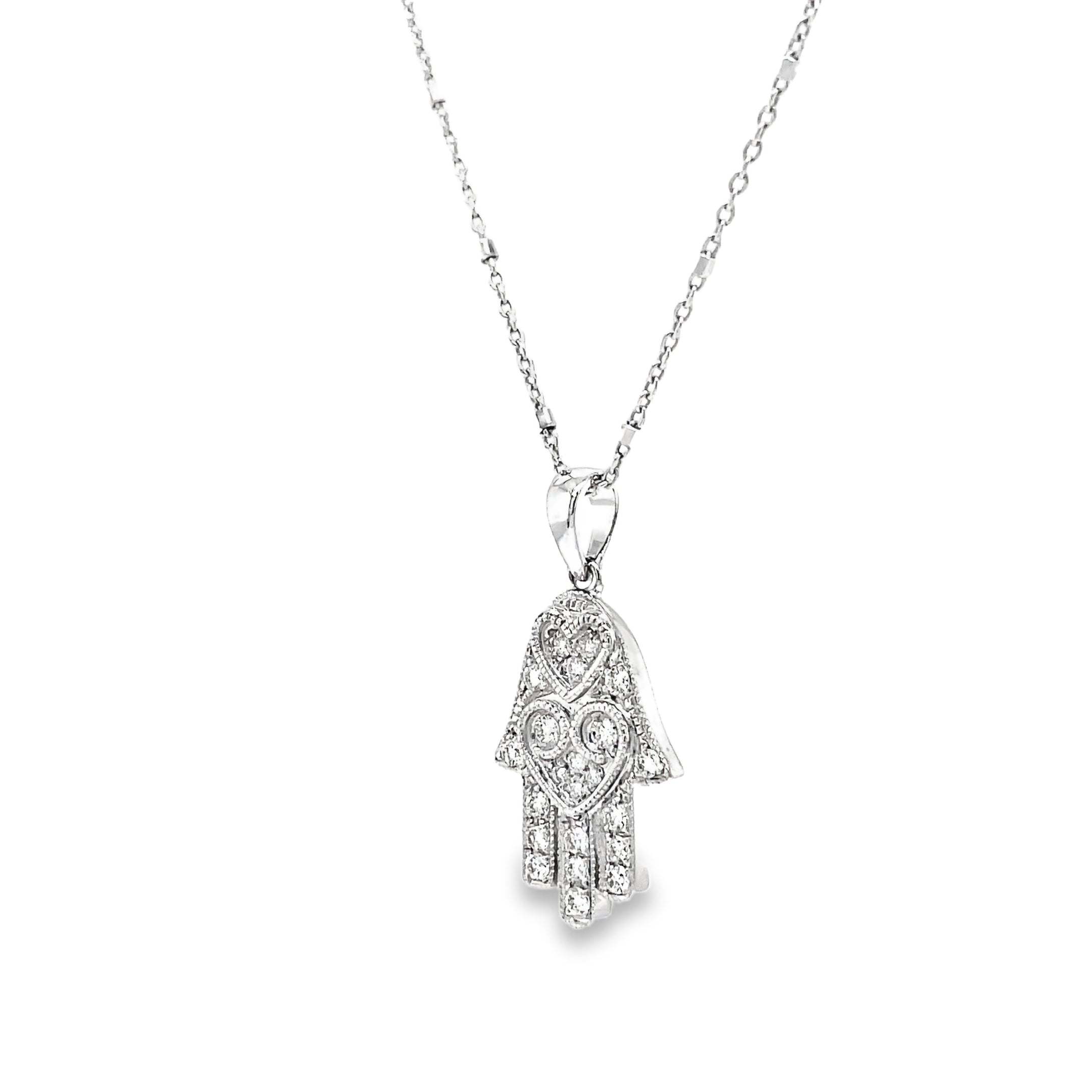 Adorn your neck with this dainty, yet classy diamond pendant necklace! Emblazoned with 0.20 carats of shimmering round diamonds set in 18k white gold, this piece features an expertly crafted hamsa with two sizeable loops and a small round diamond on the side. The lobster clasp ensures it stays securely in place on your neck at 16" long. Stylish and secure!

Italian Chain optional $350.00