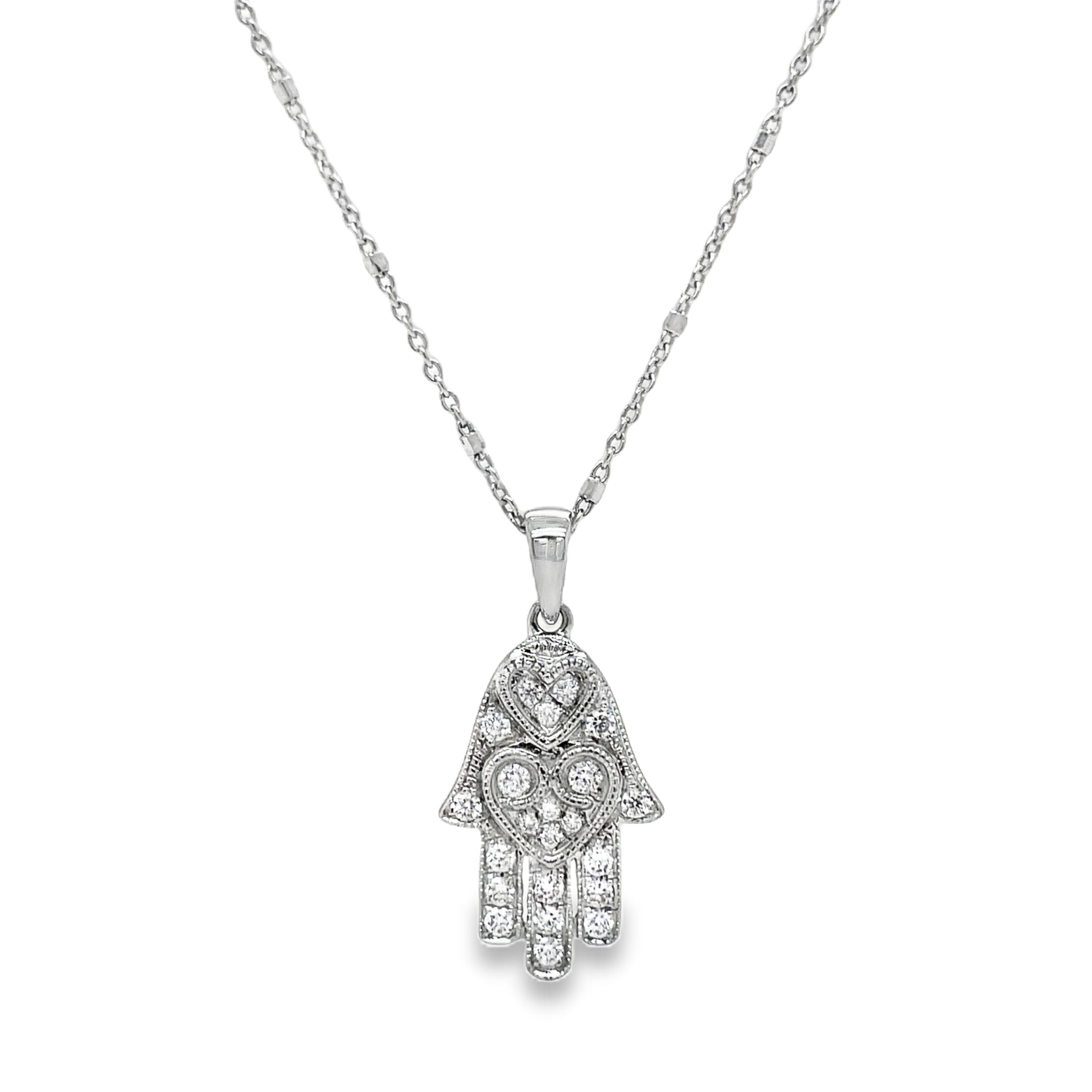 Adorn your neck with this dainty, yet classy diamond pendant necklace! Emblazoned with 0.20 carats of shimmering round diamonds set in 18k white gold, this piece features an expertly crafted hamsa with two sizeable loops and a small round diamond on the side. The lobster clasp ensures it stays securely in place on your neck at 16" long. Stylish and secure!

Italian Chain optional $350.00