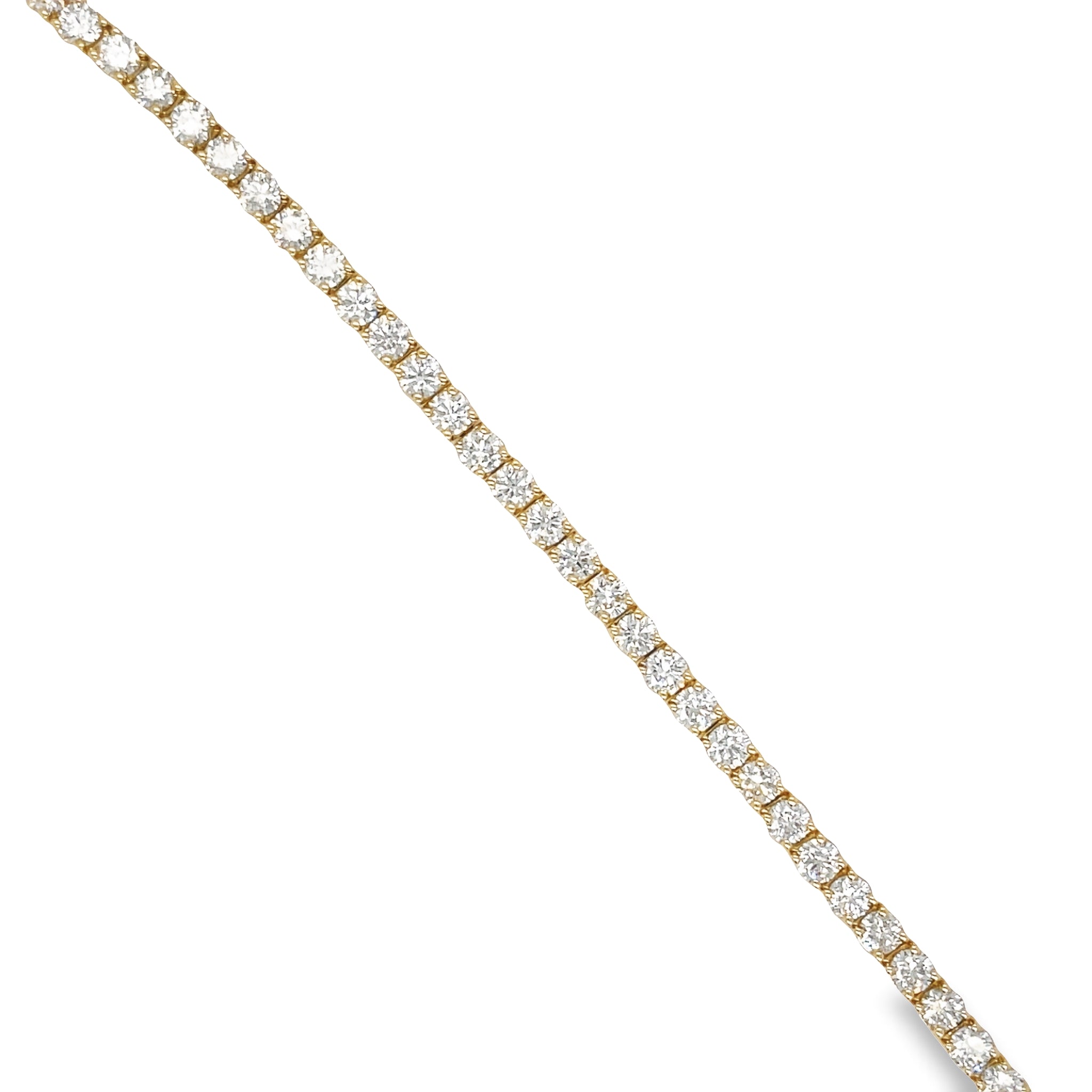 This Diamond Line Tennis Bracelet is crafted with 14k yellow gold and is encrusted with 6.51 carats of brilliant diamonds, color J and clarity VS1. The 7' length is secured with a hidden clasp for a subtle and elegant finish. Perfect for special occasions, this timeless piece will make a striking addition to any jewelry collection.