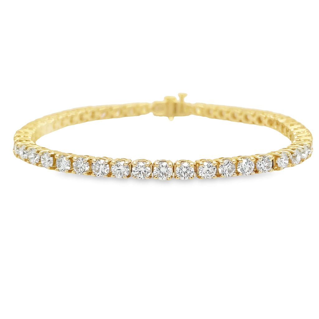 This Diamond Line Tennis Bracelet is crafted with 14k yellow gold and is encrusted with 6.51 carats of brilliant diamonds, color J and clarity VS1. The 7' length is secured with a hidden clasp for a subtle and elegant finish. Perfect for special occasions, this timeless piece will make a striking addition to any jewelry collection.