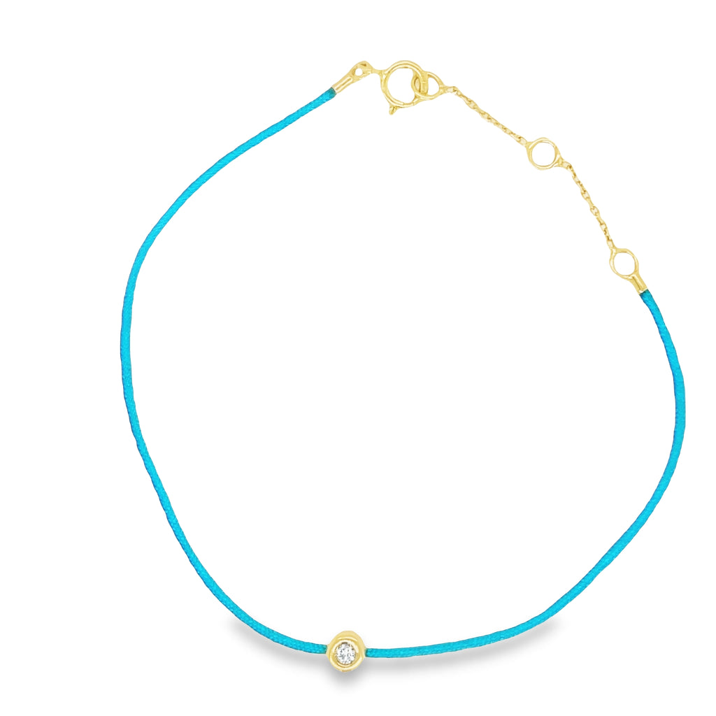 Indulge in the luxurious sparkle of this Dainty Diamond Solitaire Blue Silk Bracelet. Boasting a single bezel-set diamond set in 18K golden yellow gold, this adjustable bracelet creates an unforgettable look. The adjustable silk cord ensures a perfect fit every time. Enjoy the shimmer and shine of this lavish piece.