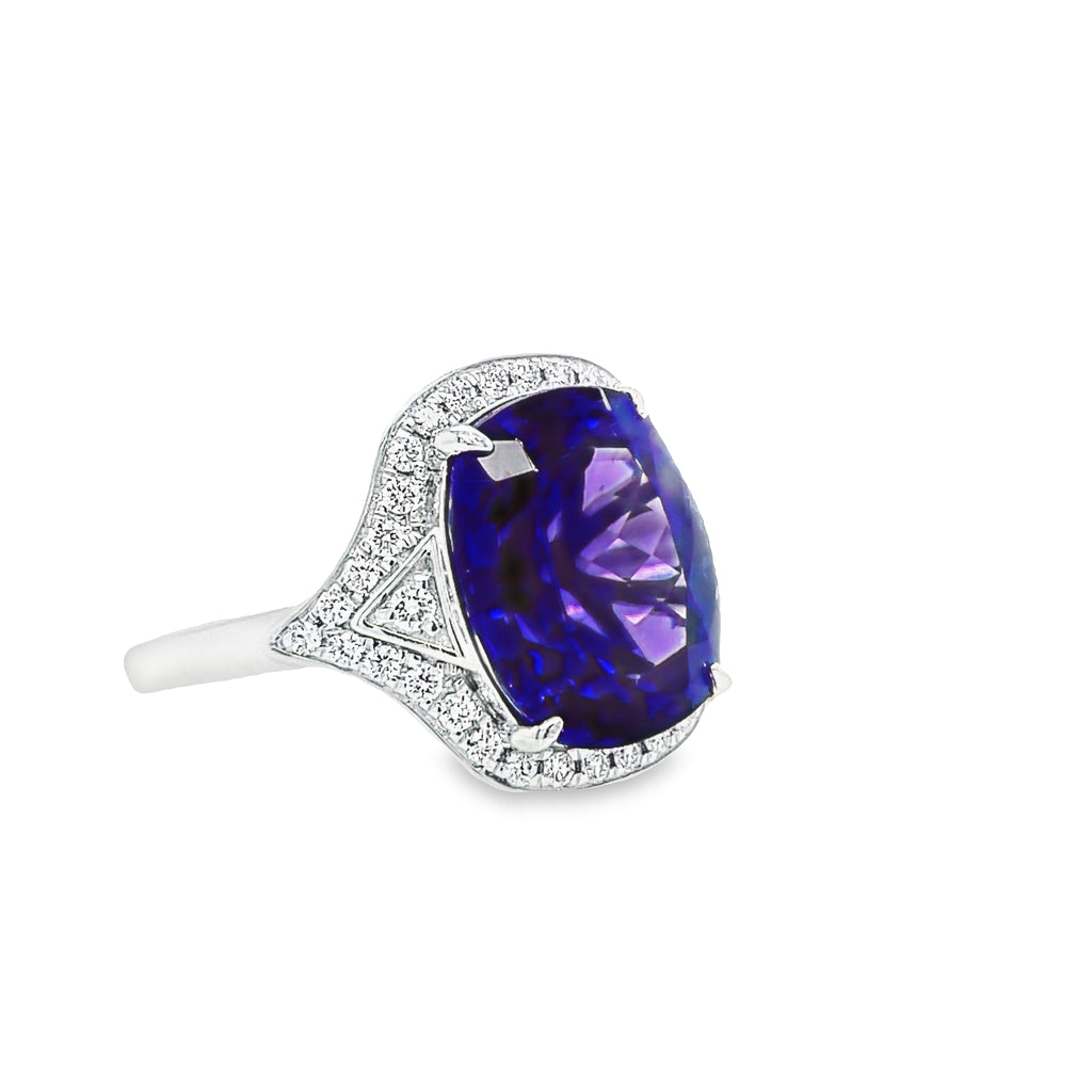 This exquisite modified radiant cut Tanzanite 6.75 cts & Diamond Cocktail Ring is a stunning statement piece. Its captivating Tanzanite center stone is accented by a halo of glittering round diamonds. Set in luxurious platinum, this piece radiates elegance and sophistication.