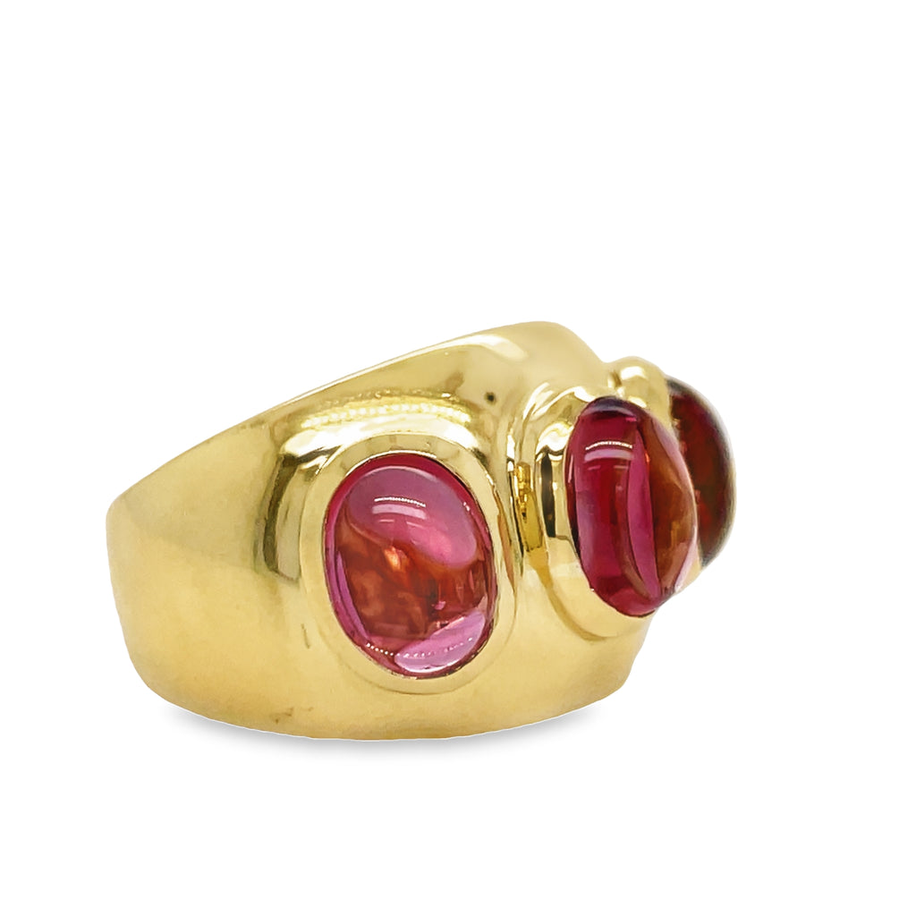 Indulge in the luxurious beauty of our Three Cabochon Pink Tourmaline Ring. Crafted with 18k yellow gold, this ring features three stunning oval cabochon pink tourmalines. Elevate any outfit and radiate confidence with this exquisite piece
