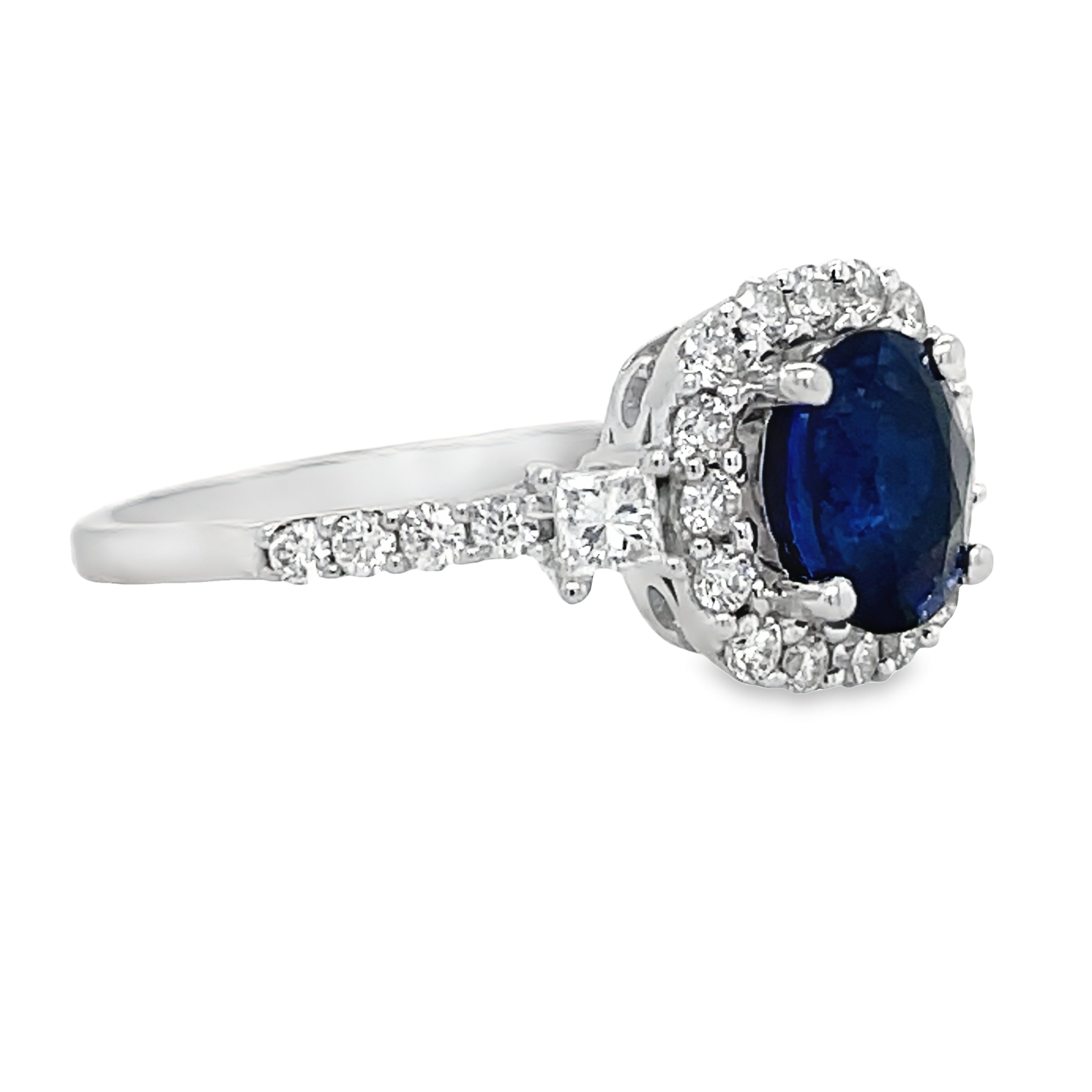 Experience luxury and elegance with our Oval Sapphire Diamond Bezel Ring. Featuring a stunning oval sapphire surrounded by princess cut and round diamonds totaling 0.59 cts, all set in a beautiful diamond bezel on an 18k white gold band. Make a statement that exudes sophistication and style.