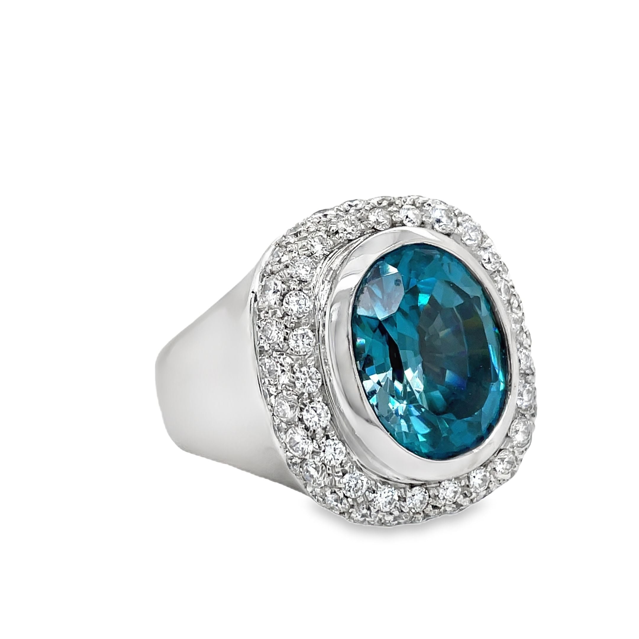 Indulge in luxury with our exquisite Italian made Blue Zircon and Diamond Cocktail Ring. Crafted with 18k white gold, the oval shape zircon (10.68 cts) shimmers with elegance, while the round diamonds (1.35 cts) add a touch of glamour. The wide gold ring completes this sophisticated and exclusive piece, making it a must-have for any fashion-forward woman.