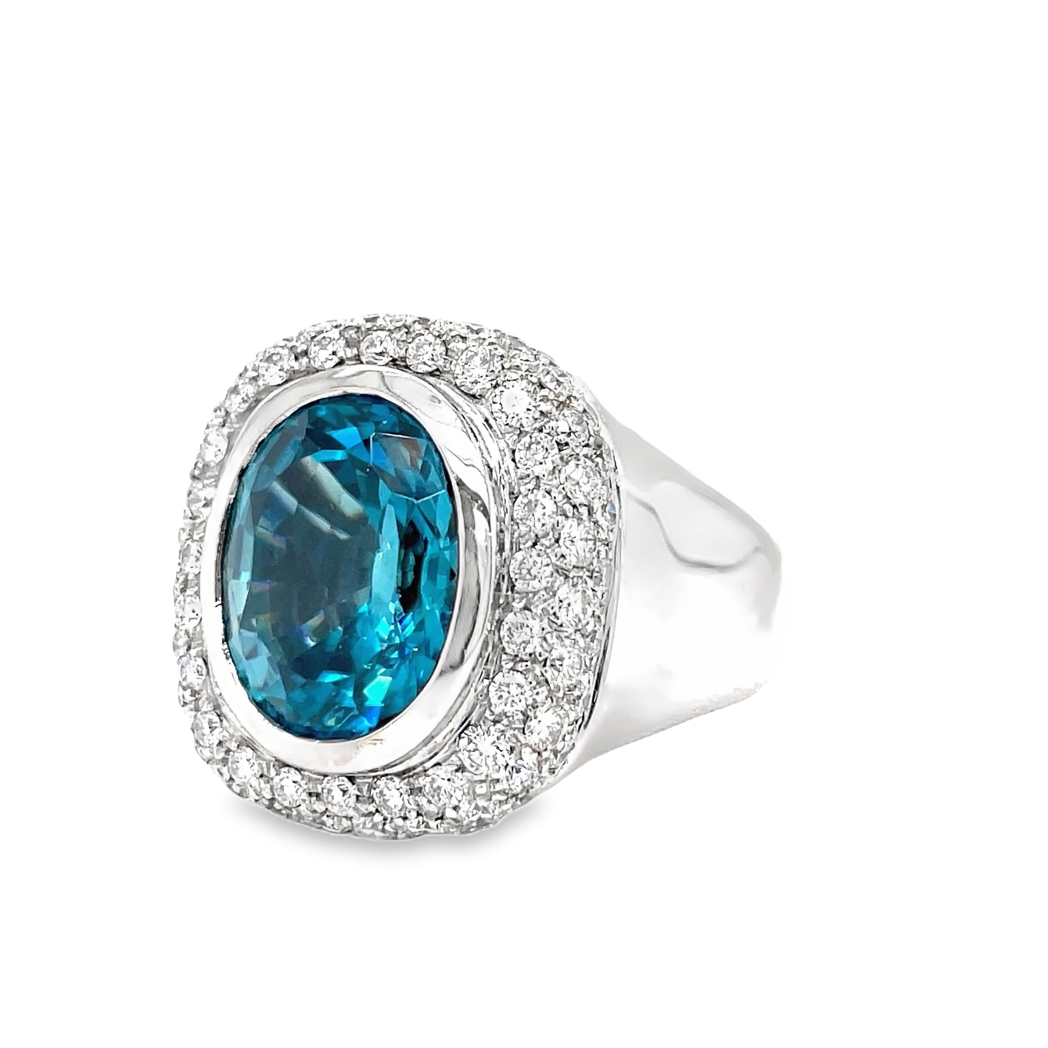 Indulge in luxury with our exquisite Italian made Blue Zircon and Diamond Cocktail Ring. Crafted with 18k white gold, the oval shape zircon (10.68 cts) shimmers with elegance, while the round diamonds (1.35 cts) add a touch of glamour. The wide gold ring completes this sophisticated and exclusive piece, making it a must-have for any fashion-forward woman.