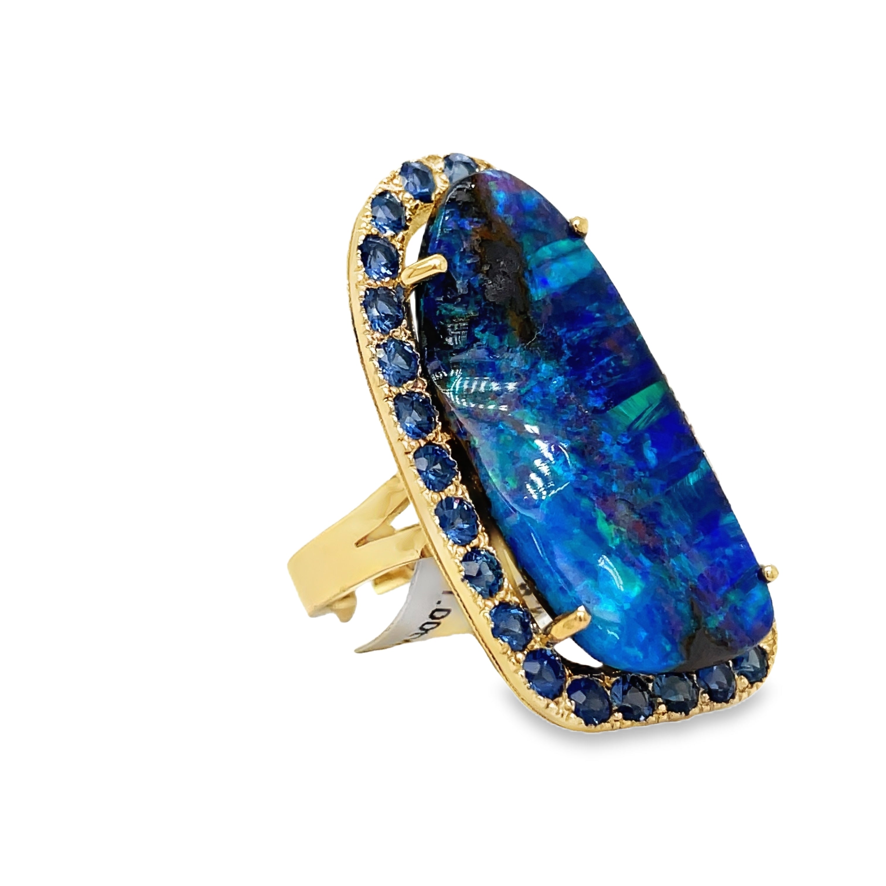 Indulge in elegance with our Hand Made Large Australian Black Opal and Sapphire Ring. Crafted with 14k yellow gold, the stunning 18.00 ct opal boasts a mesmerizing play of color. Adorned with 3.00 ct round sapphires, this piece is a true work of art.