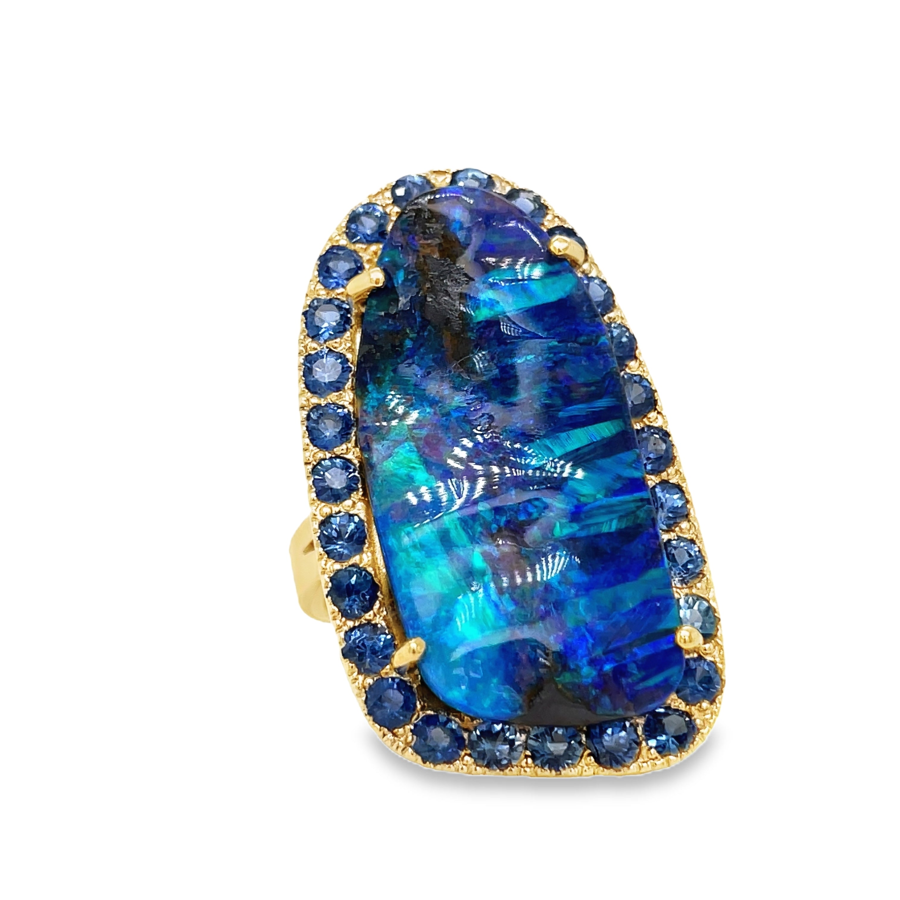 Indulge in elegance with our Hand Made Large Australian Black Opal and Sapphire Ring. Crafted with 14k yellow gold, the stunning 18.00 ct opal boasts a mesmerizing play of color. Adorned with 3.00 ct round sapphires, this piece is a true work of art.