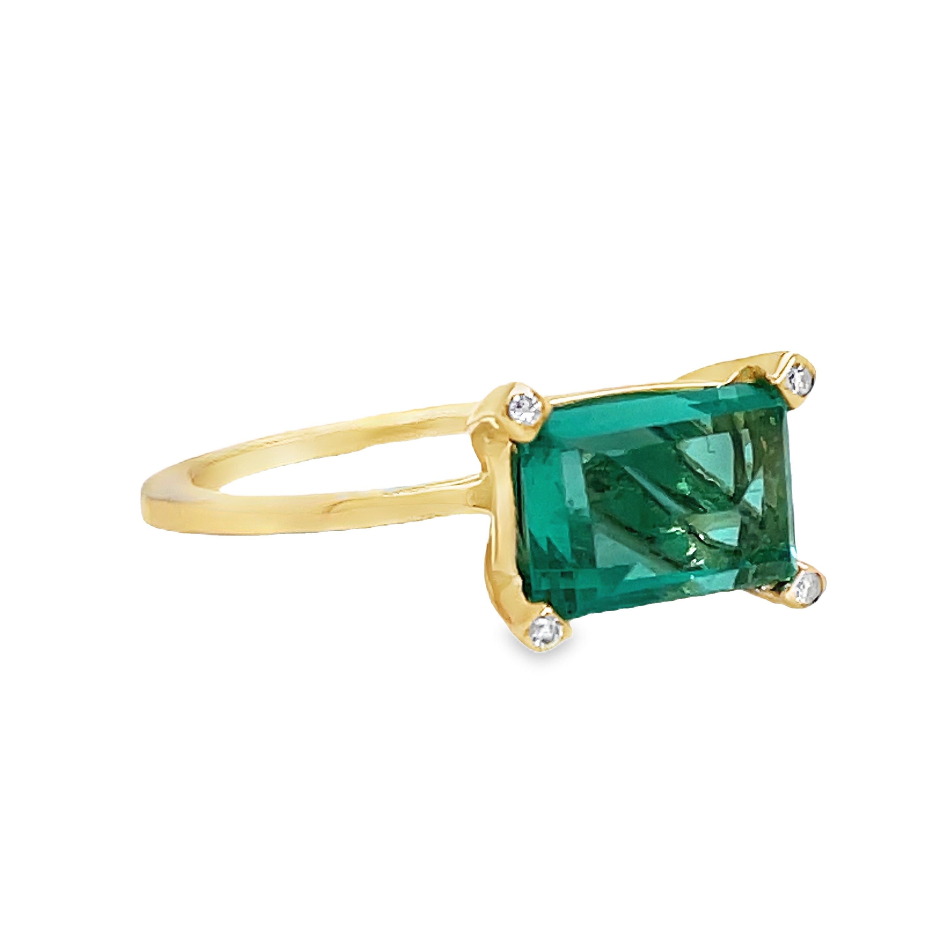 Indulge in luxury with our Horizontal Emerald Cut Emerald Ring. Crafted with 14k yellow gold, this ring features a stunning emerald cut emerald set upside down, accented by four small diamonds on each corner. The horizontal setting adds a unique touch of elegance to this timeless piece. Elevate your style with this exclusive ring.