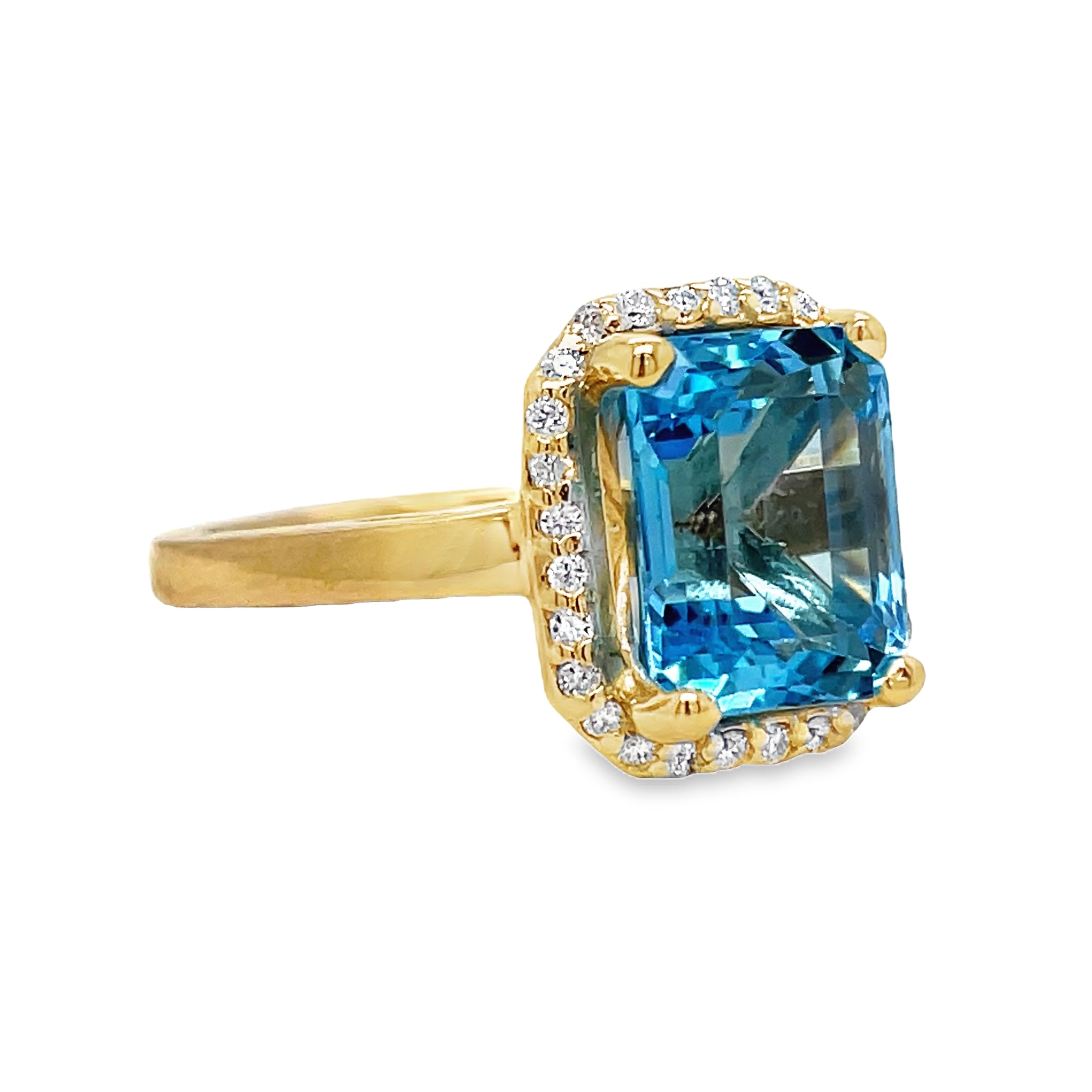 Indulge in the exquisite elegance of this Emerald Cut Blue Topaz Diamond Halo Ring. Crafted in 14k yellow gold, the cathedral style setting highlights a stunning emerald cut Blue Topaz, surrounded by sparkling round diamonds totaling 0.40 carats. A true masterpiece, perfect for any sophisticated and exclusive individual.