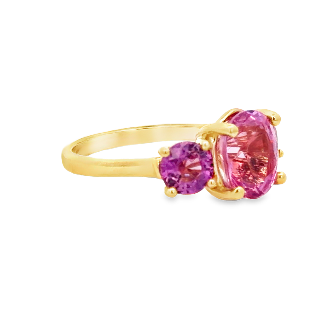 Side view of 18K Vivid Pink Sapphire Three-Stone Ring in Yellow Gold