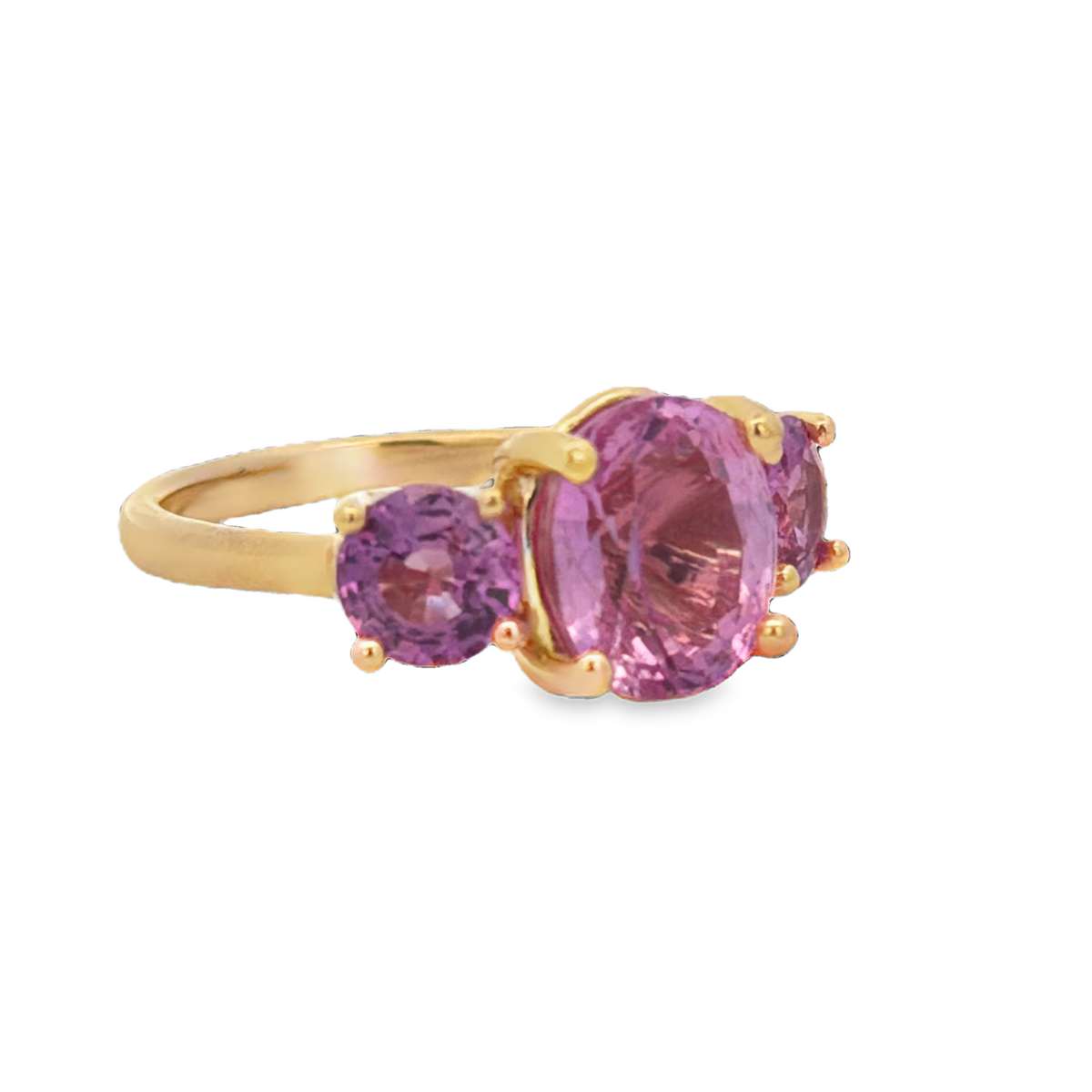 Side view of 18K Vivid Pink Sapphire Three-Stone Ring in Yellow Gold