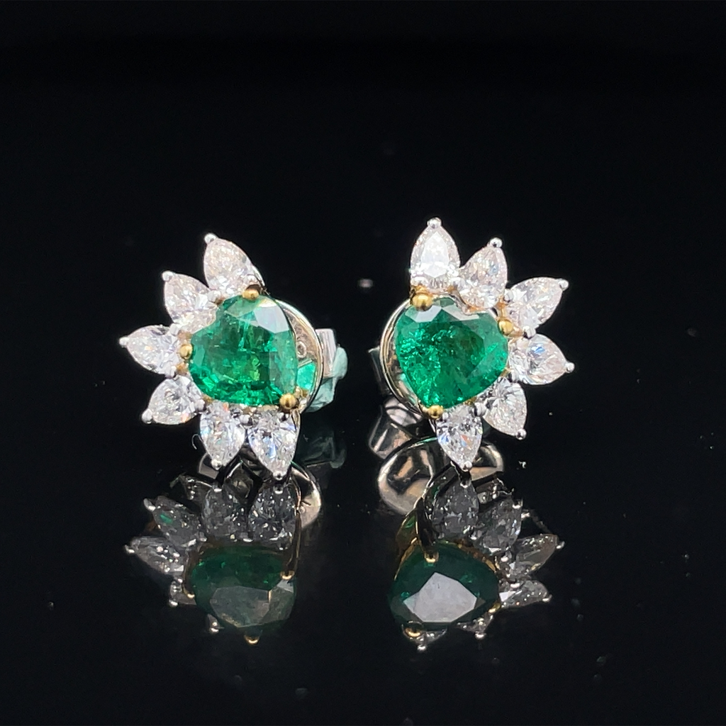 These Zambian Emerald and Marquise Diamond Stud Earrings feature a 1.33 cts heart shape cut emerald in 18k white and yellow gold, complimented by 12 marquise shape diamonds 1.02 cts. This elegant earring set is perfect for those looking to add the perfect combination of sparkle and sophistication to their look.