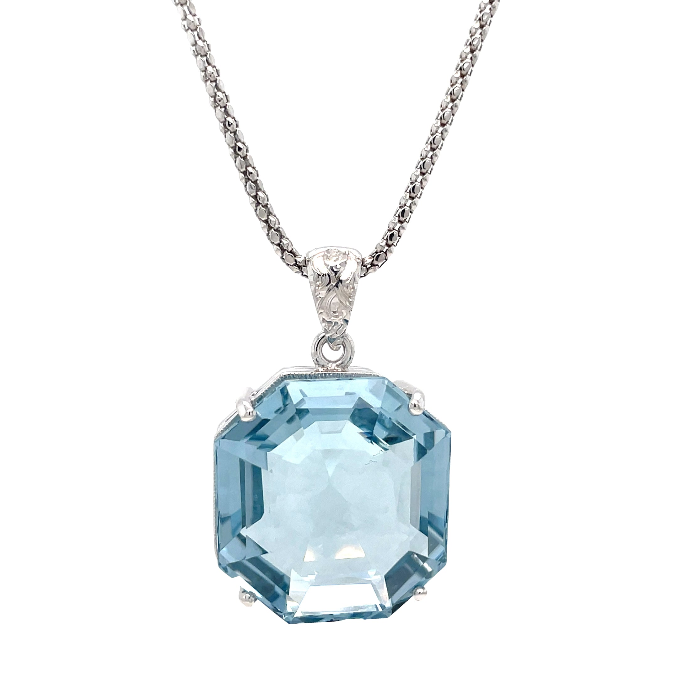 Expertly designed and crafted, our Aquamarine &amp; Diamond Necklace features a stunning octahedron aquamarine with a diamond bail. The custom-made white gold mounting adds a touch of elegance and is complemented by an Italian-made chain. Elevate any outfit with this eye-catching necklace. Chain is optional 20" long ($550)