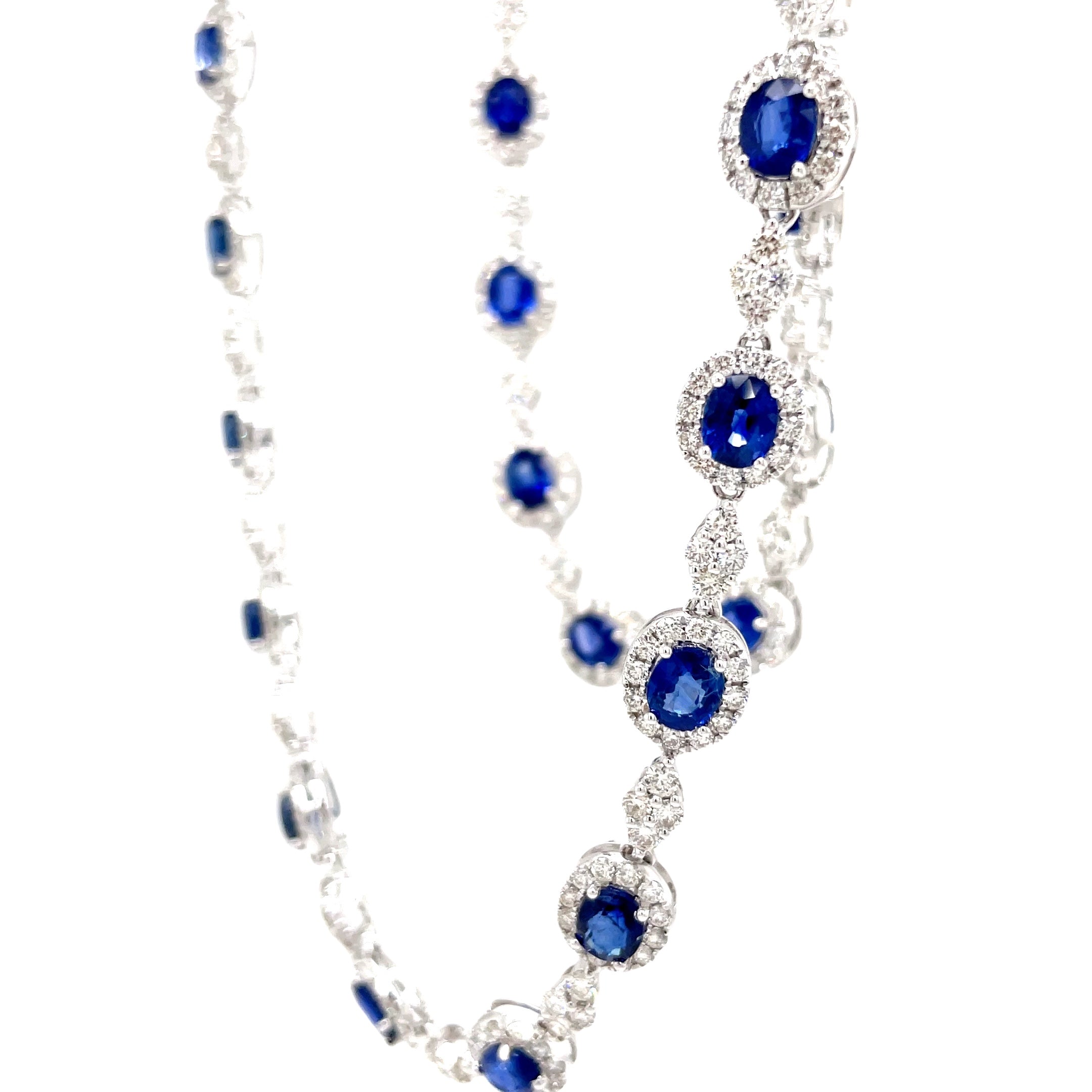 Indulge in luxury with our Blue Sapphire and Diamond Necklace. The 28 oval shape sapphires, totaling 14.67 carats, are complemented by 7.70 carats of round diamonds, set in 18k white gold. The hidden clasp ensures a seamless and elegant look, perfect for any occasion. Measuring 18", this necklace is a must-have for any sophisticated and exclusive wardrobe.