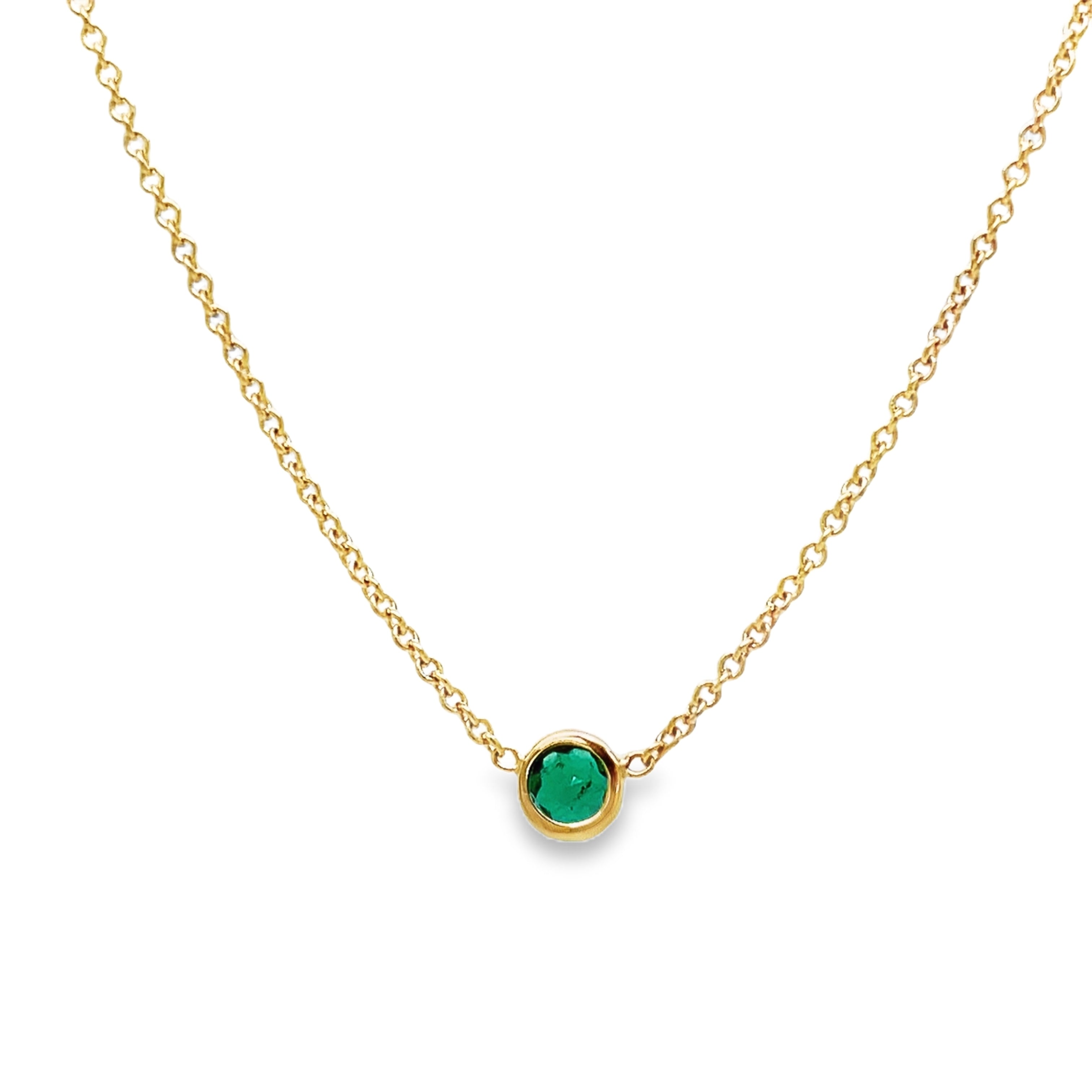 dulge in the exquisite elegance of our Small Colombian Round Emerald Necklace. The dainty 14k yellow gold chain delicately showcases a stunning round emerald, evoking luxury and sophistication. With a secure lobster clasp, this 16" necklace is the perfect choice for a touch of timeless beauty.