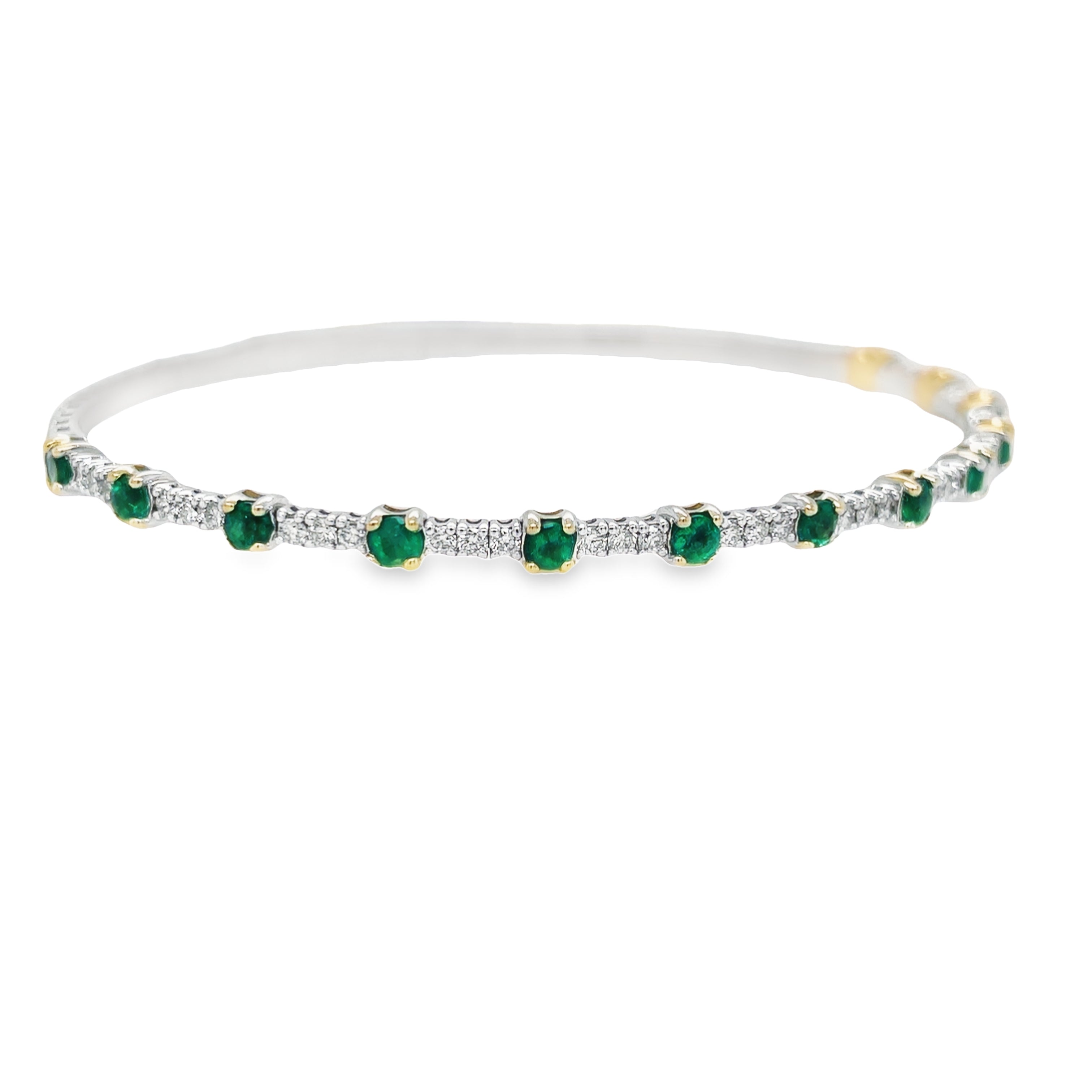 This luxurious dainty bangle bracelet crafted in 18K white gold is set with 0.57 carats of round diamonds and round emeralds 0.91 cts. It is the perfect accessory to add a subtle sparkle to any ensemble or stack multiple for a bolder look.  Hinge system