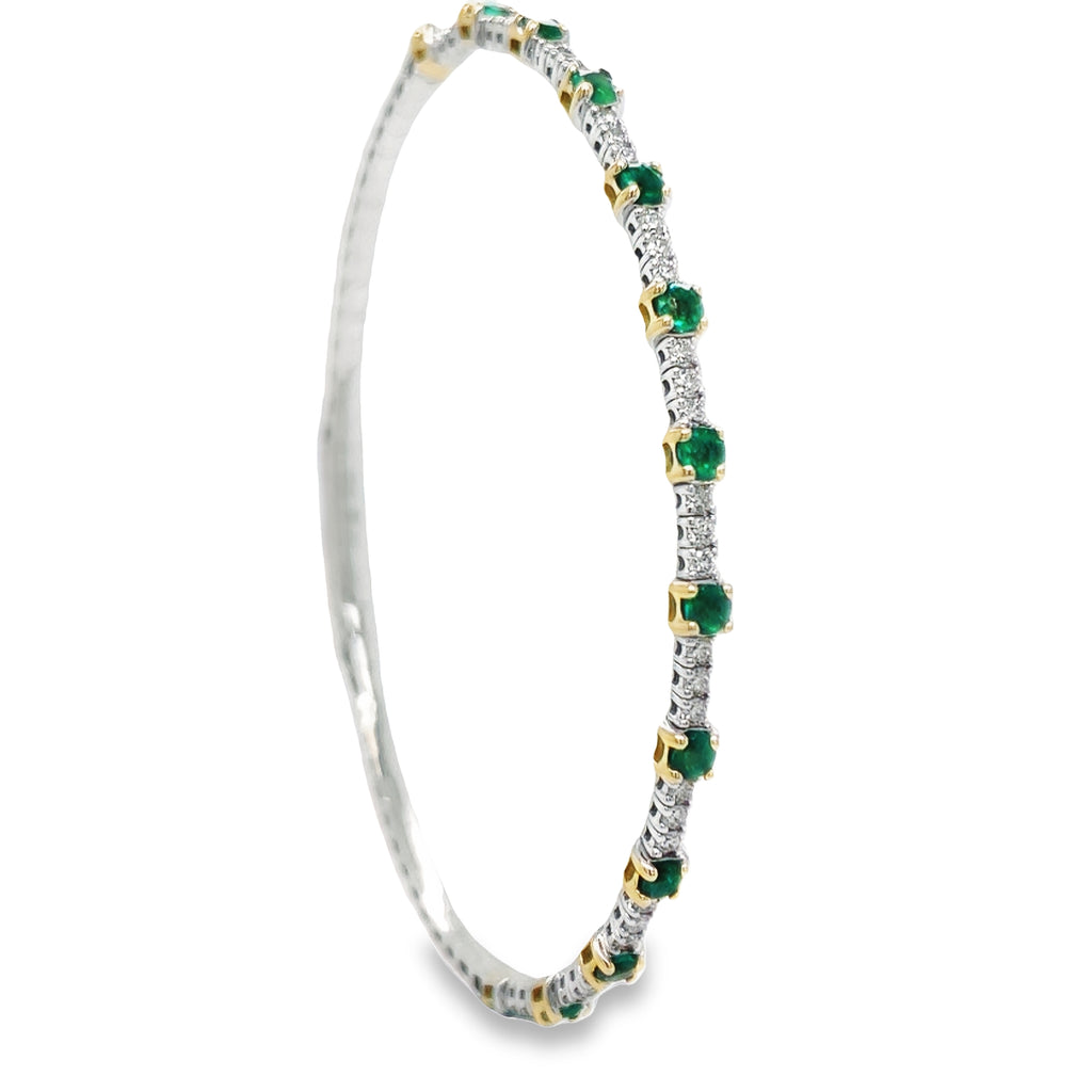 This luxurious dainty bangle bracelet crafted in 18K white gold is set with 0.57 carats of round diamonds and round emeralds 0.91 cts. It is the perfect accessory to add a subtle sparkle to any ensemble or stack multiple for a bolder look.  Hinge system
