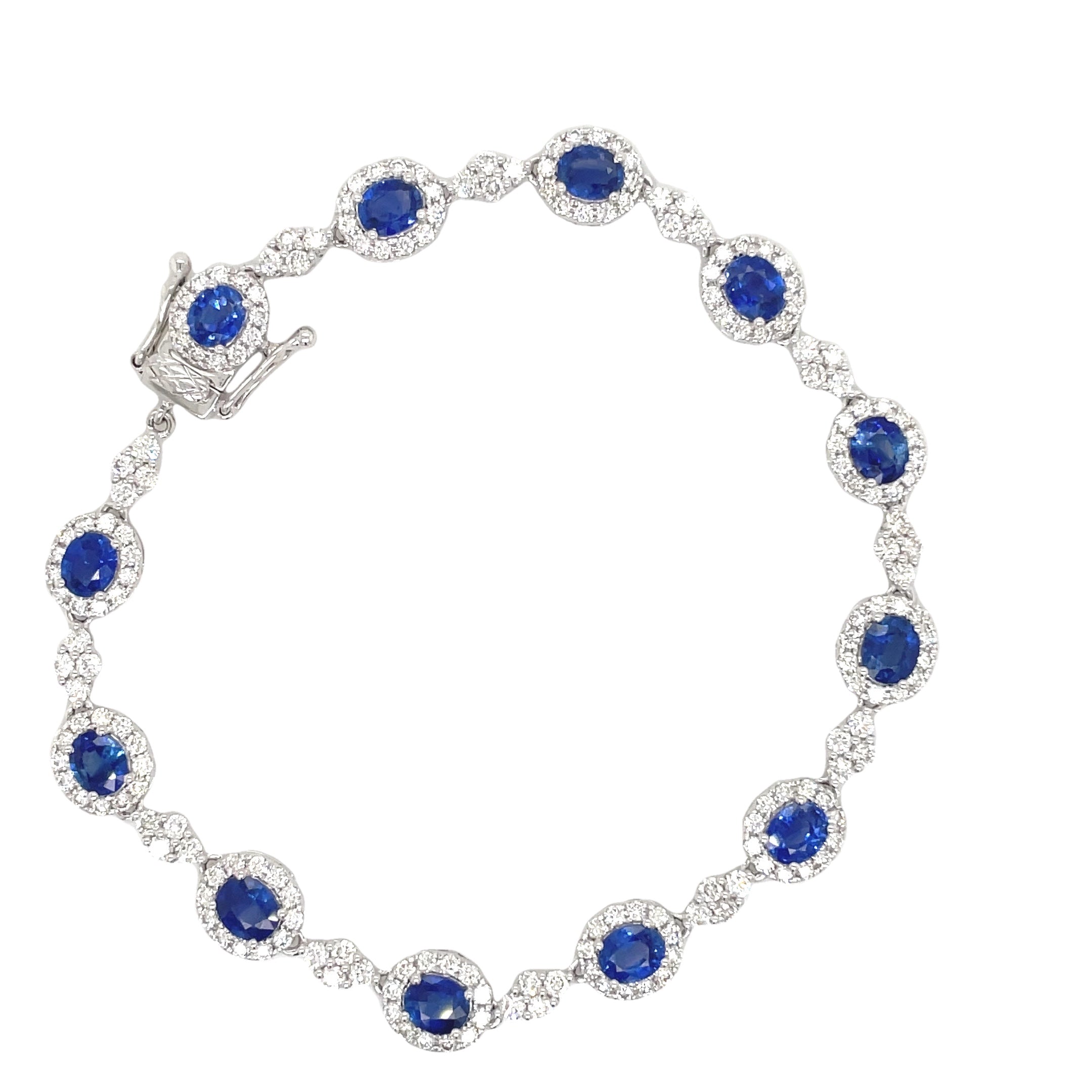 ndulge in luxury with our Blue Sapphire and Diamond Bracelet. The oval shape sapphires, totaling 5.97 carats, are complemented by 3.08 carats of round diamonds, set in 18k white gold. The hidden clasp ensures a seamless and elegant look, perfect for any occasion. Measuring 7.5", this bracelet is a must-have for any sophisticated and exclusive wardrobe.