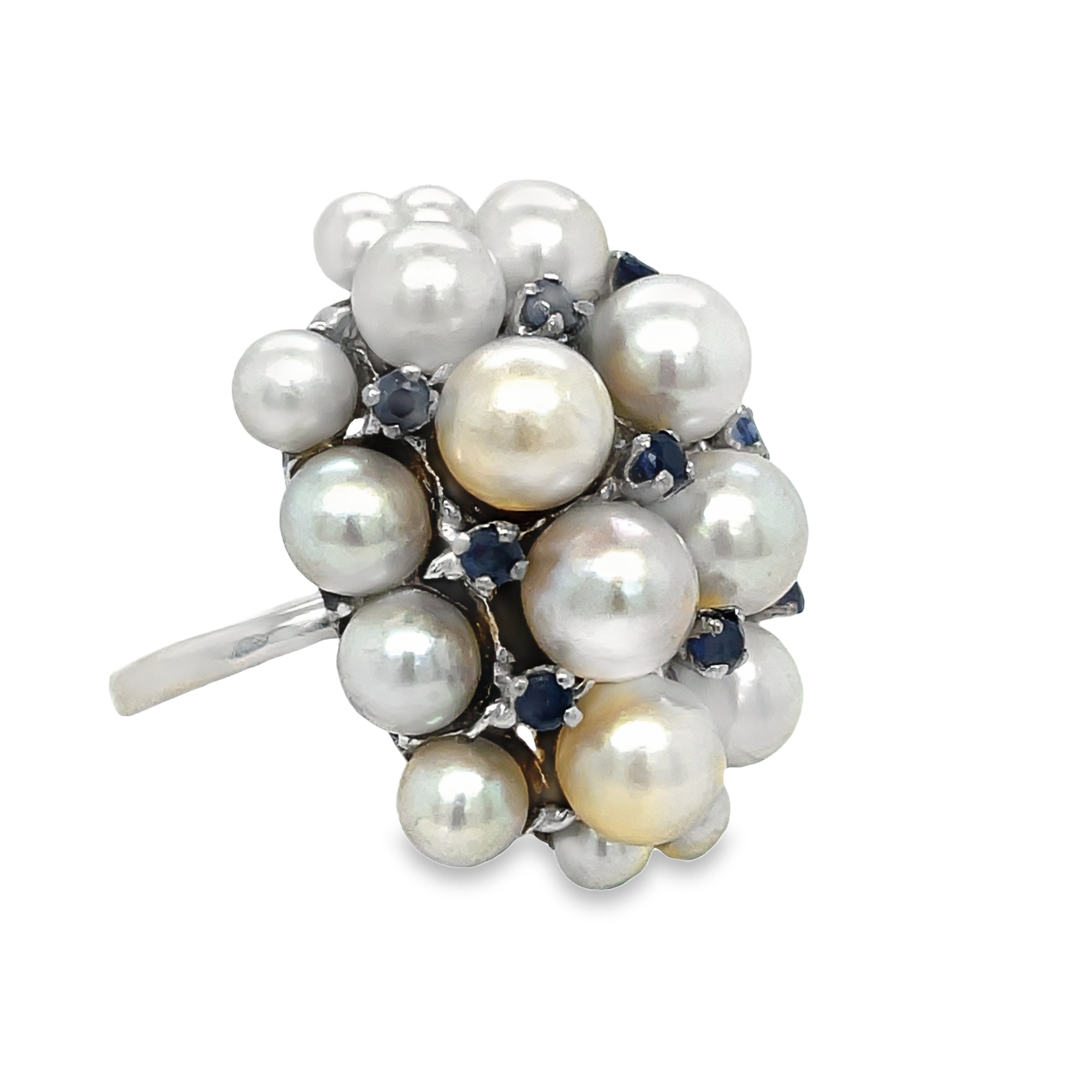 This stunning ring features a cluster of lustrous pearls and dazzling sapphires set in 14k white gold. With a 5.5 size, this piece is the perfect addition to any estate collection. The mixture of small and large pearls adds depth and texture, while the round sapphires bring a touch of elegance. Elevate your style with this unique and timeless ring.