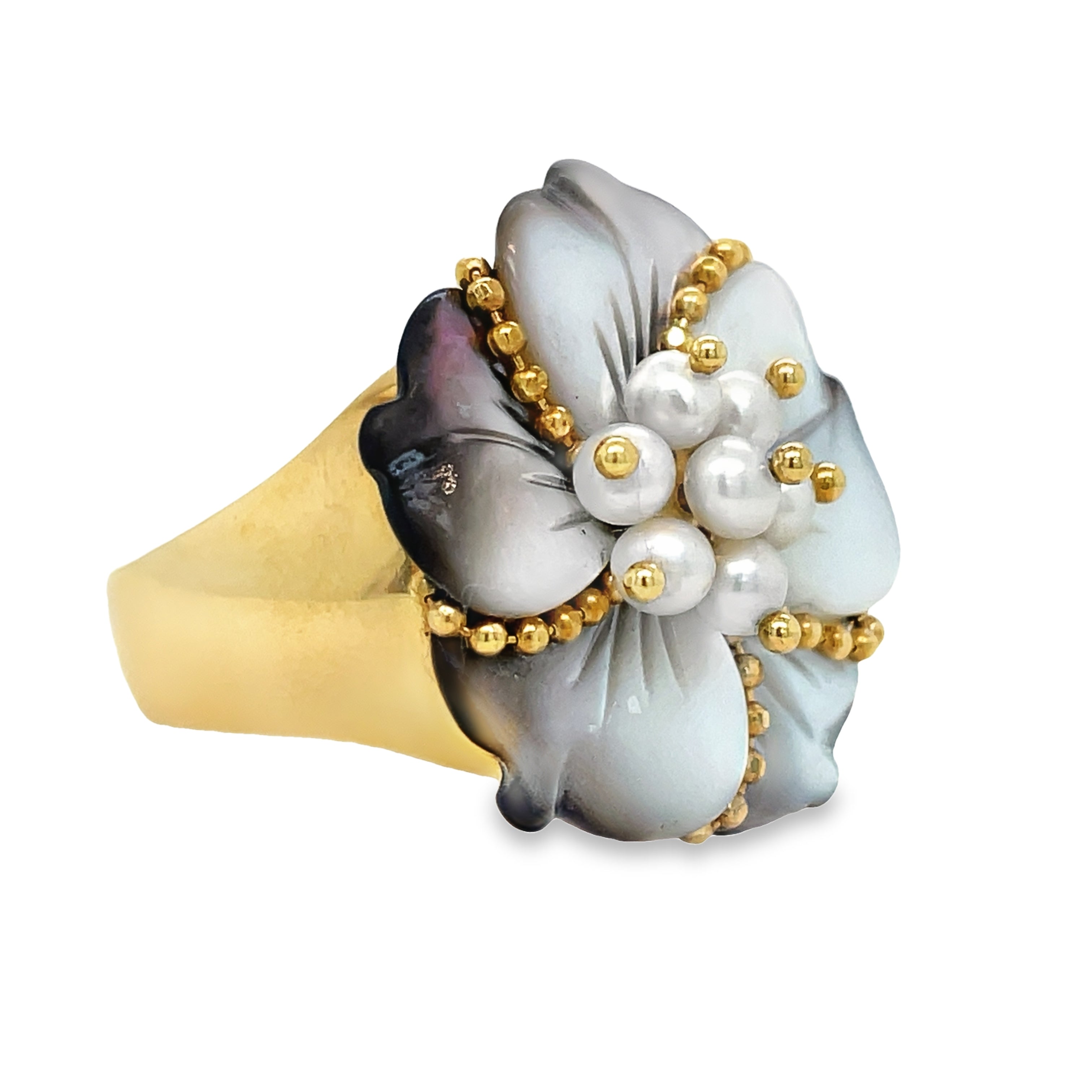 This exquisite ring features six mother of pearl petals and seven small pearls encased in 18k yellow gold. The delicate yellow gold trim adds a touch of sophistication to the ring. Perfect for adding a touch of elegance to any outfit. Available in size 6.5.