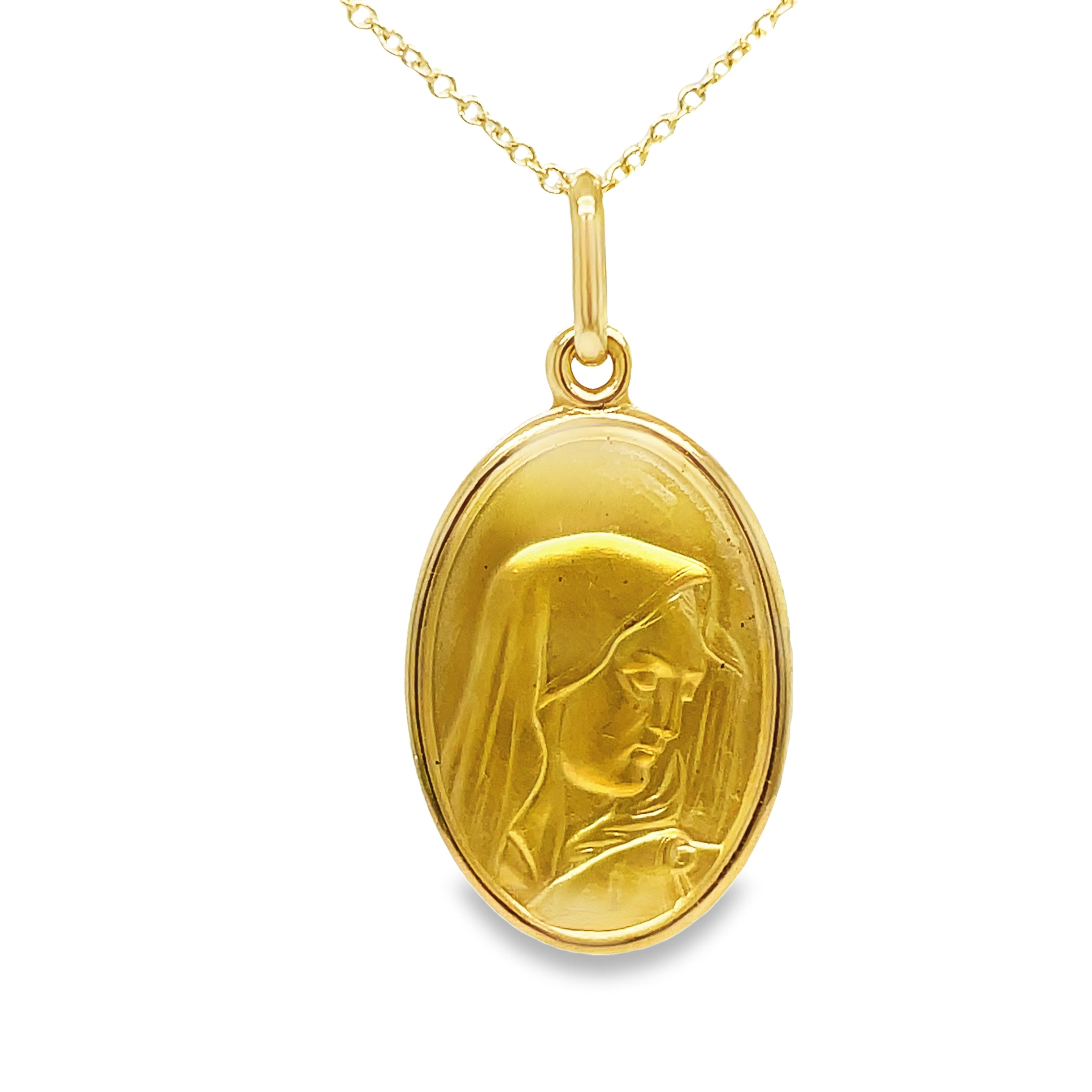 Crafted with 18k Italian yellow gold, this pendant necklace features a stunning Madonna Virgin medal with a matte finish. Measuring 27.00 x 15.00 mm, this elegant piece is a beautiful addition to any jewelry collection. Chain sold separately for $350.00 (18K). Enhance your style with this exquisite necklace.