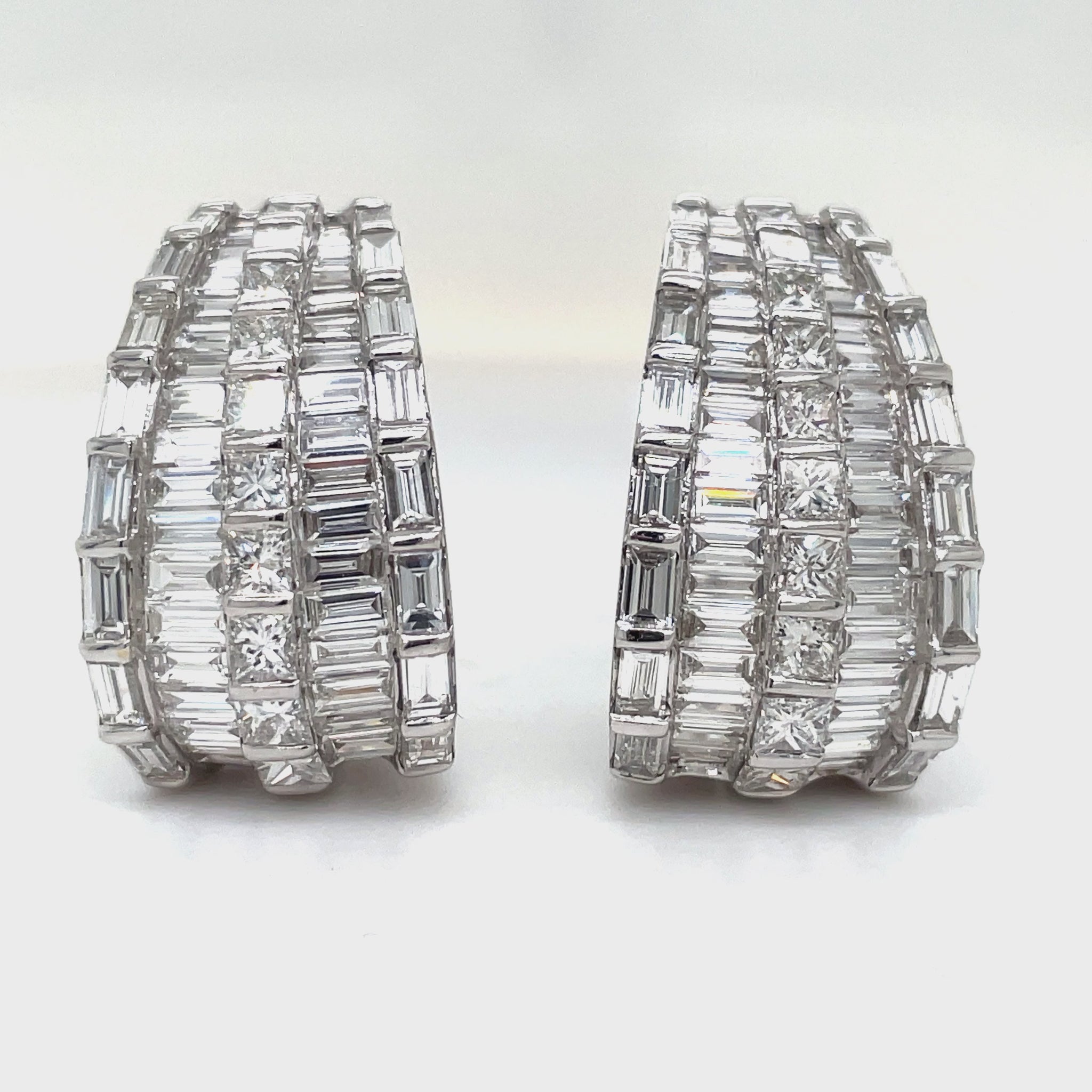 Expertly crafted in 18k white gold, these stunning drop earrings feature a mix of baguette and round diamonds totaling 6.47 cts. With a secure omega clip system, these high-quality diamonds will add elegance and sparkle to any outfit.