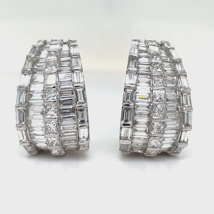 Expertly crafted in 18k white gold, these stunning drop earrings feature a mix of baguette and round diamonds totaling 6.47 cts. With a secure omega clip system, these high-quality diamonds will add elegance and sparkle to any outfit.