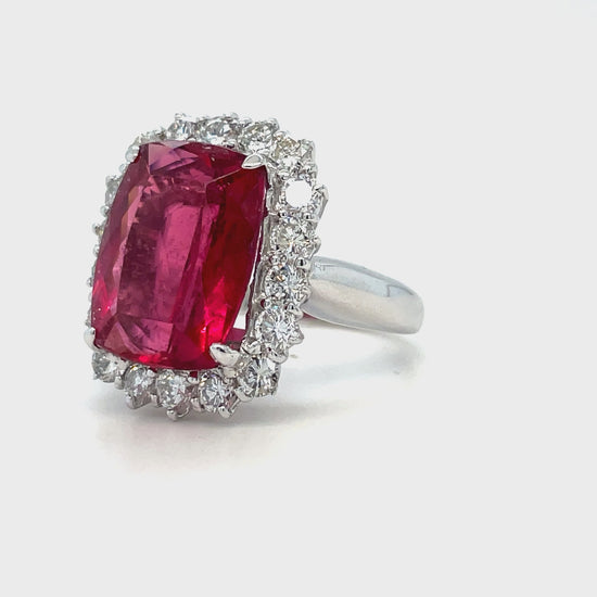 This exquisite modified radiant cut Rubilite & Diamond Cocktail Ring is a stunning statement piece. Its captivating rubilite tourmaline center stone is accented by a halo of glittering round diamonds with a total carat weight of 1.92 cts. Set in luxurious platinum, this piece radiates elegance and sophistication.