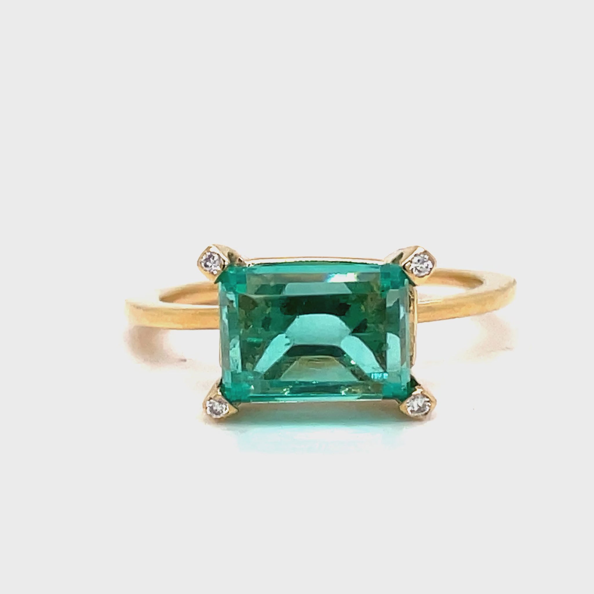 Indulge in luxury with our Horizontal Emerald Cut Emerald Ring. Crafted with 14k yellow gold, this ring features a stunning emerald cut emerald set upside down, accented by four small diamonds on each corner. The horizontal setting adds a unique touch of elegance to this timeless piece. Elevate your style with this exclusive ring.