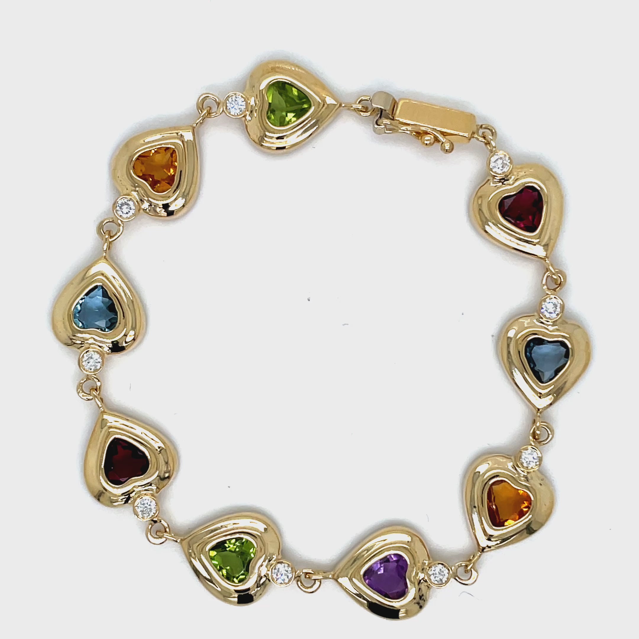 ndulge in luxury with our Multicolor Gem Heart Shape Yellow Gold Bracelet. Crafted with 14k yellow gold, this bracelet features stunning amethyst, peridot, citrine, blue topaz, and diamonds. The secure clasp ensures a perfect fit, making it the perfect accessory for any occasion. Measures 6.5" long.