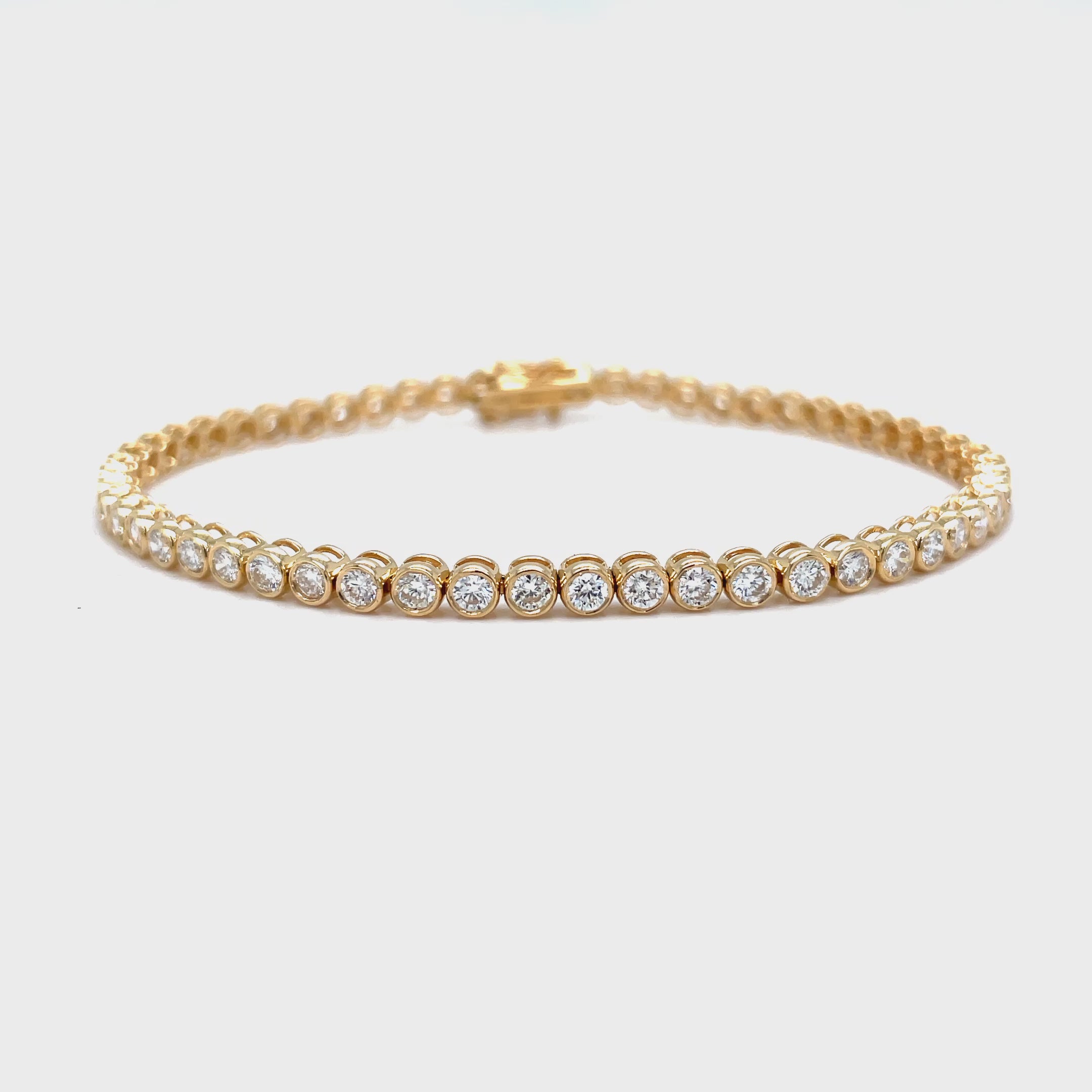 his luxurious 14k yellow gold bracelet features 2.92 carats of round diamonds, each expertly bezel-set for added sophistication. With a color rating of G/H and a clarity rating of SI1, this bracelet is truly a masterpiece. The double figure eight design adds a touch of elegance to this already exclusive piece. Elevate any outfit with this stunning bezel diamond tennis bracelet.