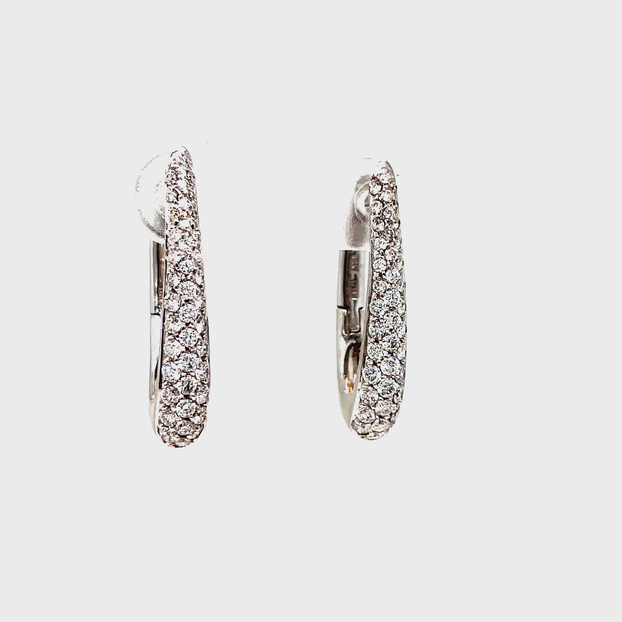 Accent your look with these exquisite Oval Shape Diamond Pave Hoop Earrings. Crafted from 18k white gold and adorned with 1.07 cts of diamond pave, these Italian-made earrings are both elegant and secure with a 1" long length and secure latch system. Elevate your style with luxury.