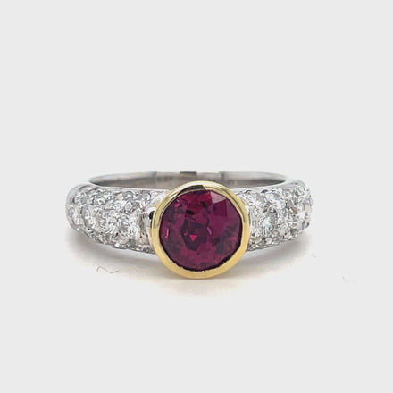 This exquisite Two-Tone Rhodolite Diamond Ring features a vibrant rhodolite stone bezel set in 18k two tone gold, accented with round diamonds totaling 1.05 carats. Elevate your style with this unique and stunning piece.