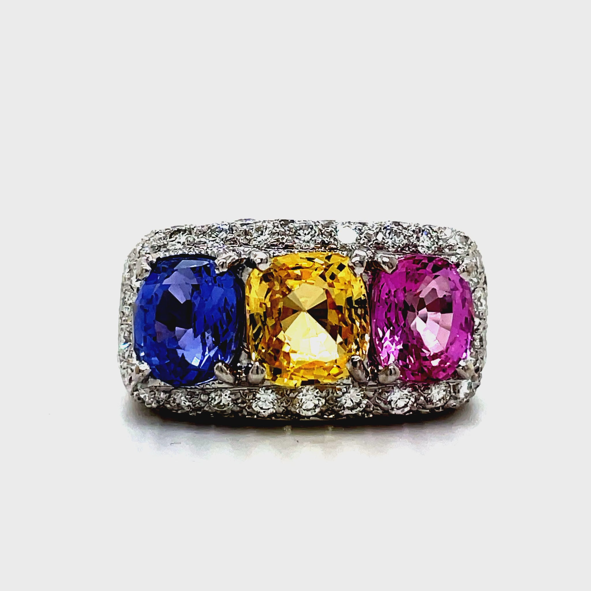 Introducing our Tricolor Sapphire Ring, a true masterpiece. The 4.50 cts of oval shaped pink, yellow, and blue sapphires create a captivating combination, set in 18k white gold. Adorned with 1.50 cts of pave set diamonds, this ring exudes luxury and elegance. Elevate your style with this exclusive piece.