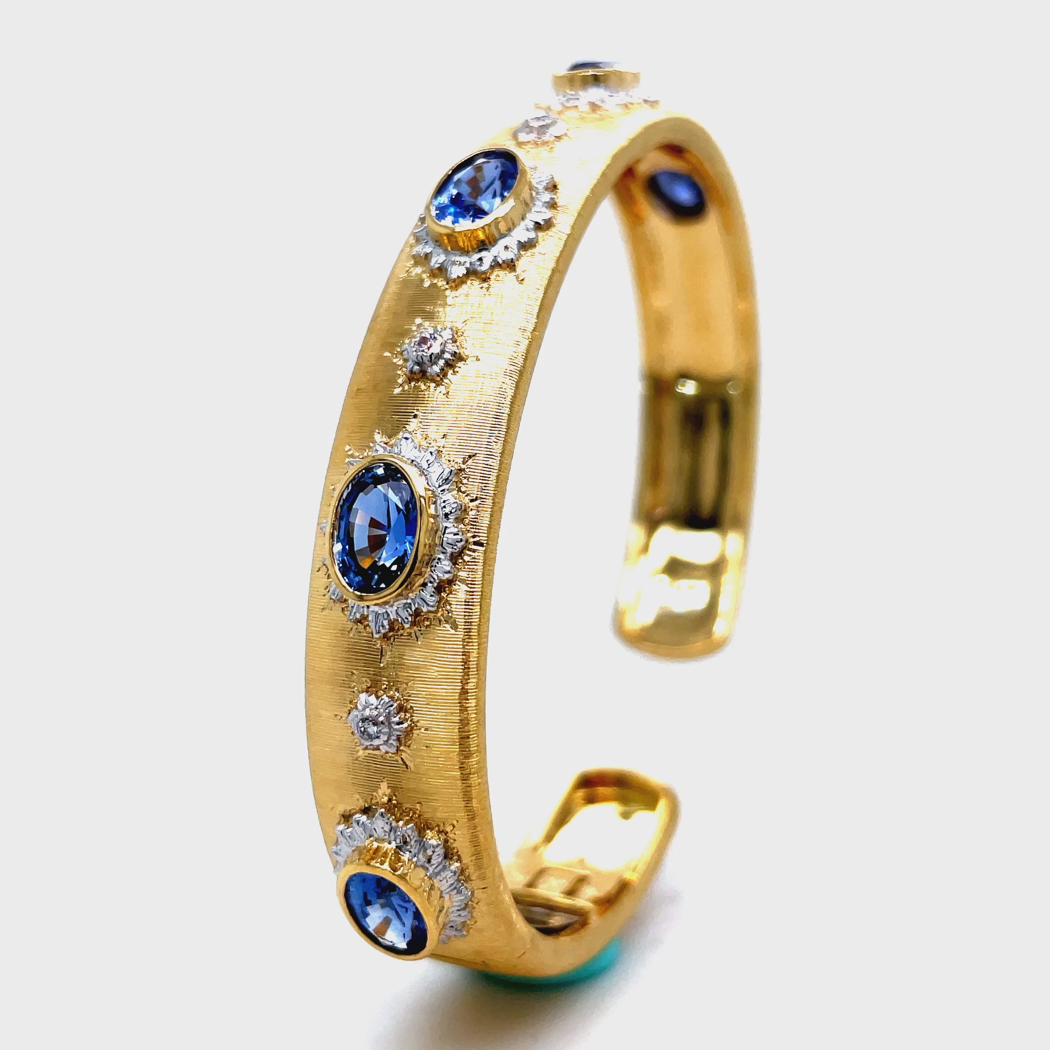 Elevate your style with our Italian 18K Yellow Gold Bangle Bracelet. Handcrafted with 18K gold, this exquisite piece features five oval sapphires and round diamonds for a total of 3.98 cts. The brushed finish adds a touch of elegance and sophistication. Indulge in luxury and make a statement with this Italian-made bracelet.