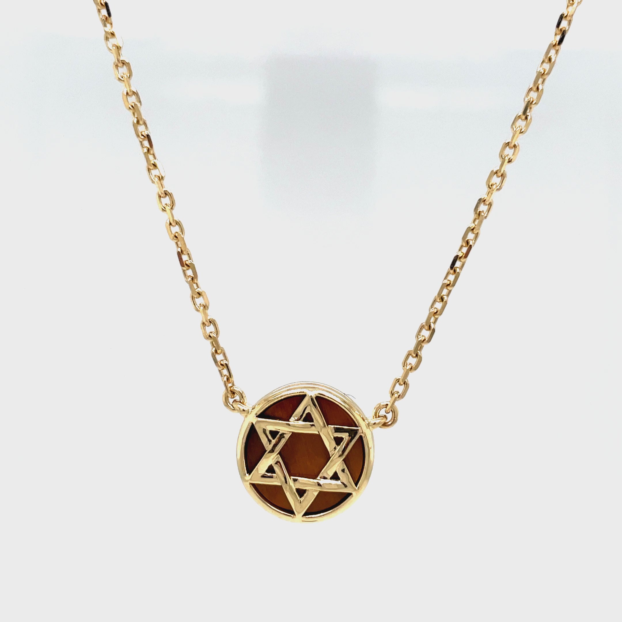 Discover the beauty of our 14k Tiger Eye Star of David Necklace. Handcrafted with 15.00 mm of 14k yellow gold and adorned with solid tiger eye background. The 18" long chain features a secure lobster clasp with a sizing loop at 16", ensuring a perfect fit. Elevate your style and embrace luxury with this exclusive piece.