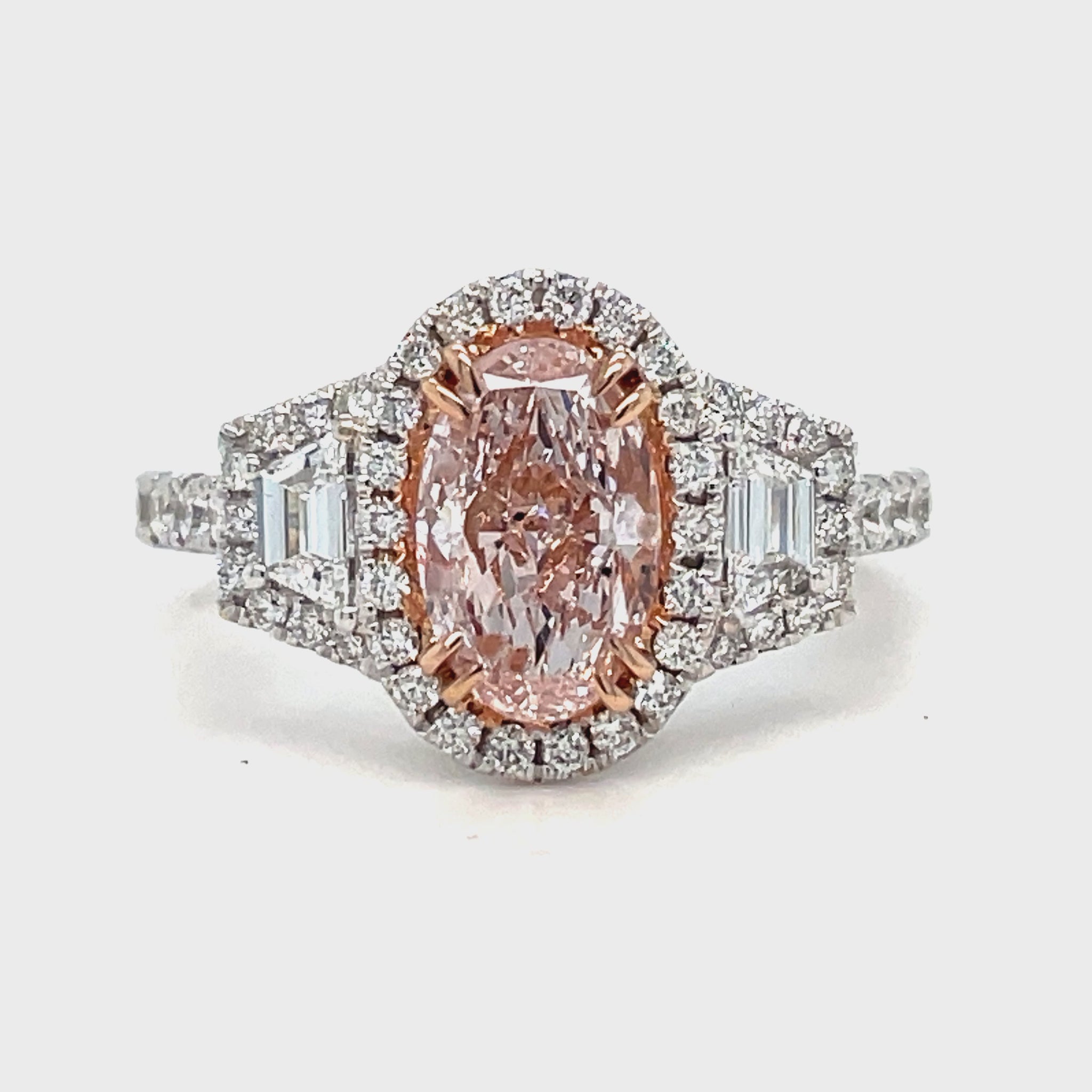 "Indulge in the rare beauty of our GIA certified 1.40 carat oval shaped pink diamond engagement ring. With two kite shaped diamonds and a round diamond bezel totaling 0.90 carats, this 18k white gold ring radiates sophistication and luxury. Make every moment sparkle with this stunning, one-of-a-kind piece."