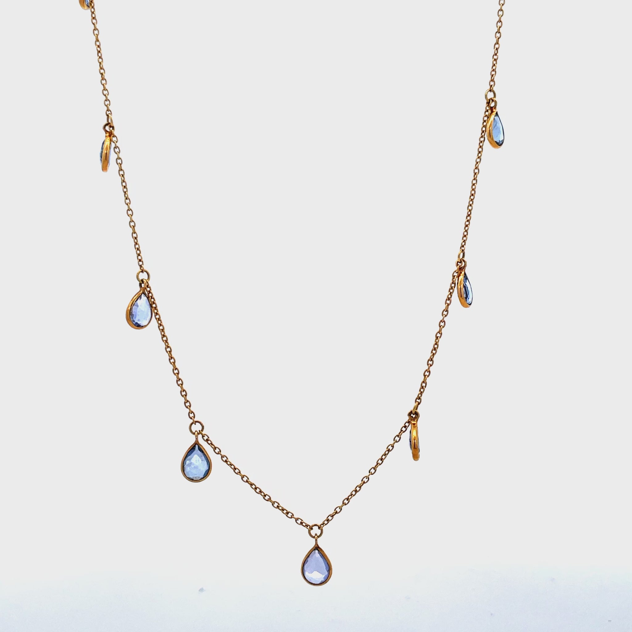 Try on view of 18k Yellow Gold Pear-Cut Tanzanite Station Necklace