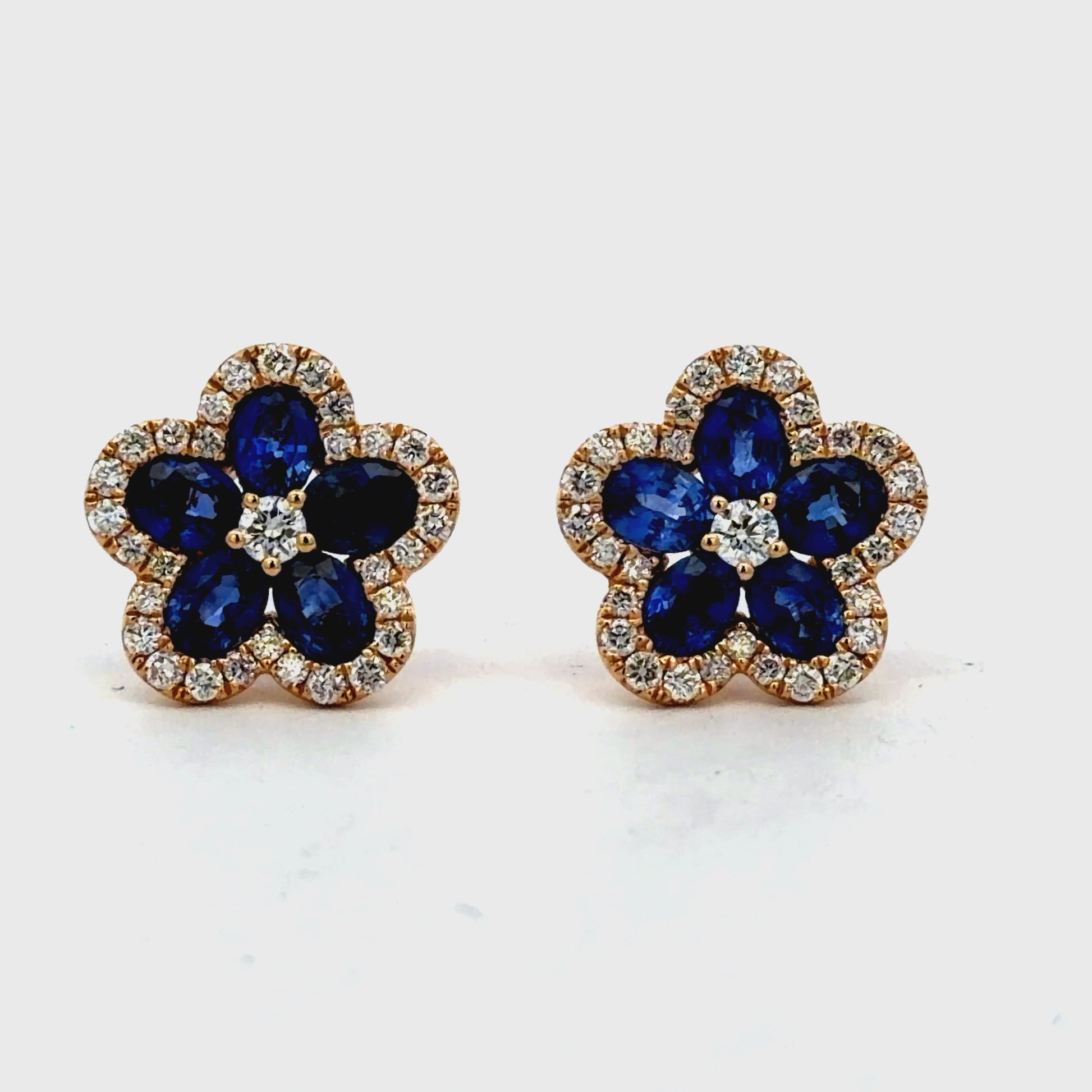 Try on view of 18k Yellow Gold Royal Blue Sapphire Floral Halo Stud Earrings