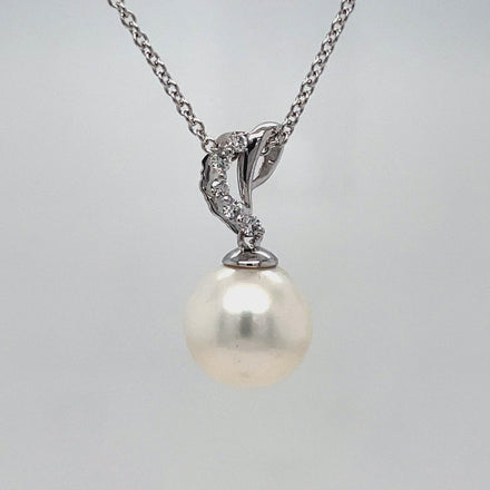 This 14k white gold necklace features a stunning South Sea pearl with great luster and color measuring 10.00 mm. The pearl is accented by a five stone diamond pendant and comes accompanied by an 18" white gold chain. Elevate any look with this elegant and timeless piece.