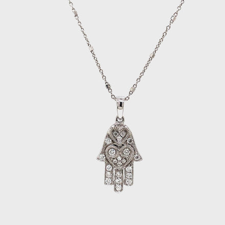 Adorn your neck with this dainty, yet classy diamond pendant necklace! Emblazoned with 0.20 carats of shimmering round diamonds set in 18k white gold, this piece features an expertly crafted hamsa with two sizeable loops and a small round diamond on the side. The lobster clasp ensures it stays securely in place on your neck at 16" long. Stylish and secure!

Italian Chain optional $350.00