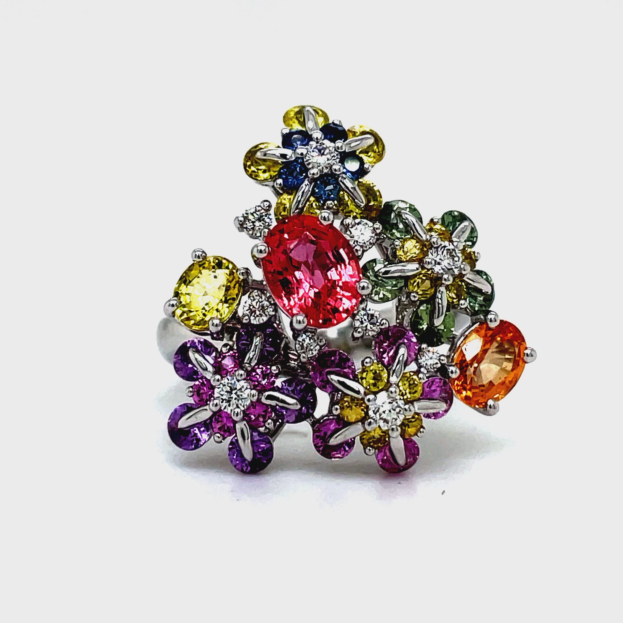 Indulge in the delicate beauty of our Multicolor Sapphire &amp; Diamond Flower Motif Ring. Adorned with 3.22 carats of multicolored sapphire stones and 0.17 carats of round diamonds, this flower-inspired ring exudes elegance and sophistication. Crafted with 18k white gold, it is a true masterpiece of refined luxury.