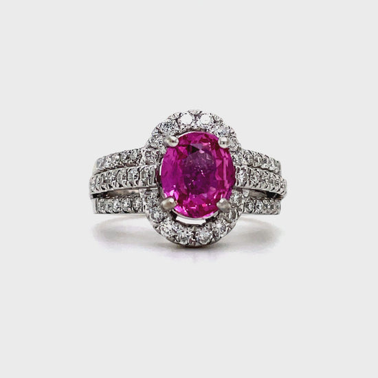 This stunning Oval Pink Sapphire Diamond Ring boasts 3.00 carats of oval pink sapphire, complemented by a halo of 0.73 carats of diamonds and a triple diamond row design in 18k white gold. Radiate elegance and sophistication with this luxurious and exclusive piece.


